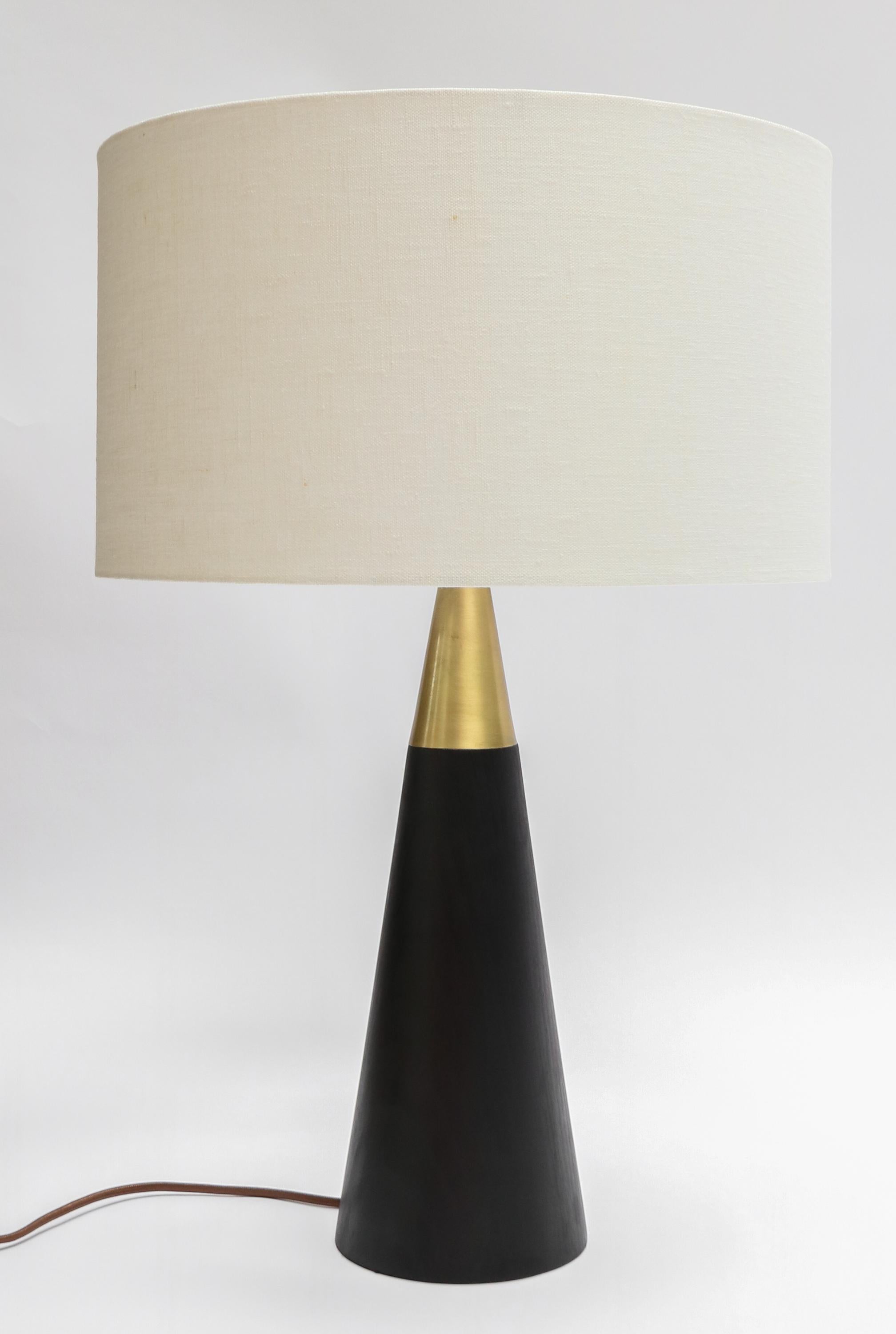 Custom table lamp with brass and black wood base with ivory linen shade by Adesso Imports.