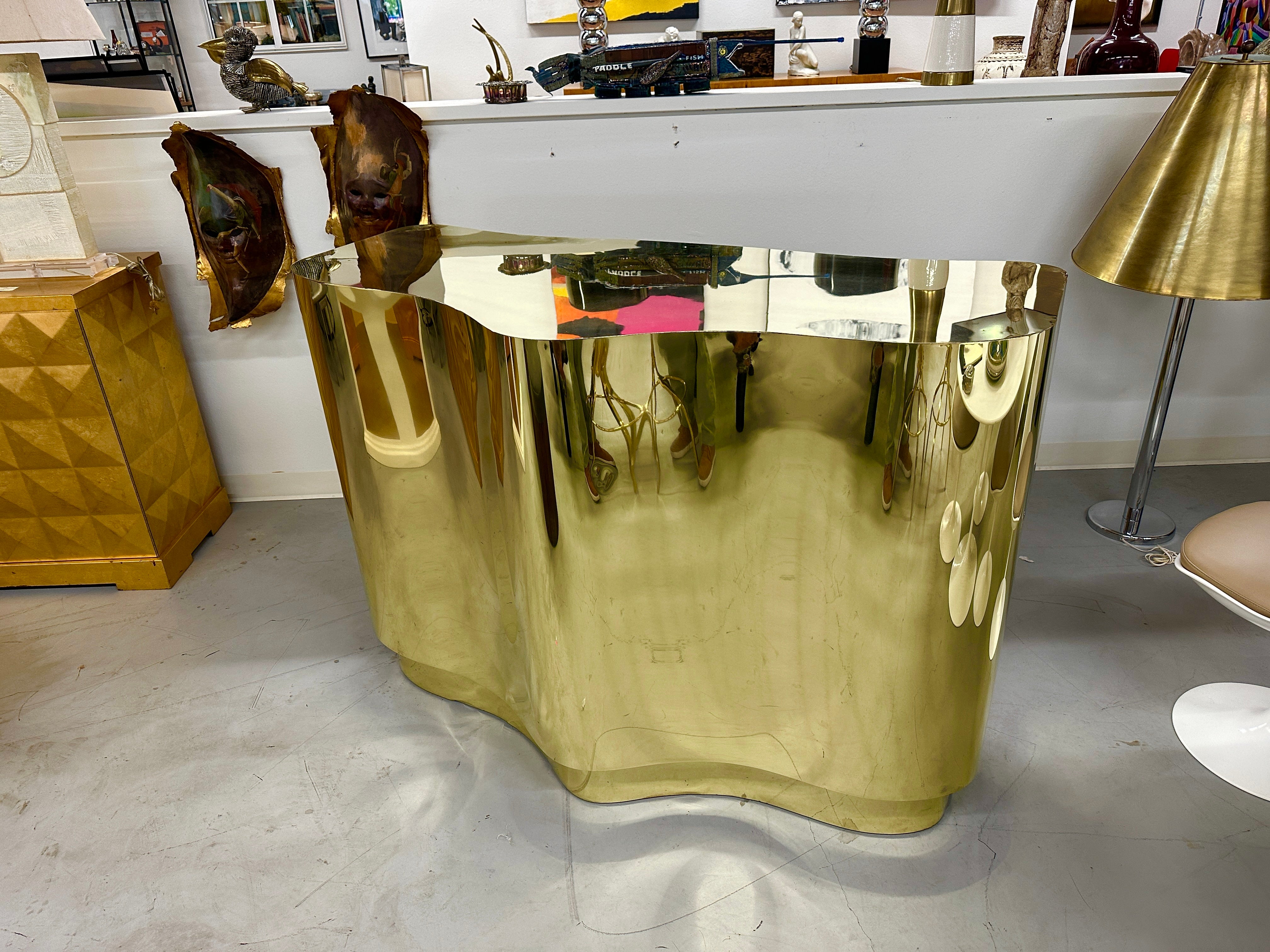 Beautiful custom  brass bar in a cloud or biomorphic shape. This piece was custom made for a wonderful Beverly Hills home in the 1990s. It has sheets of brass attached to a wood frame. There are 6 adjustable shelves on the back side. We have paired