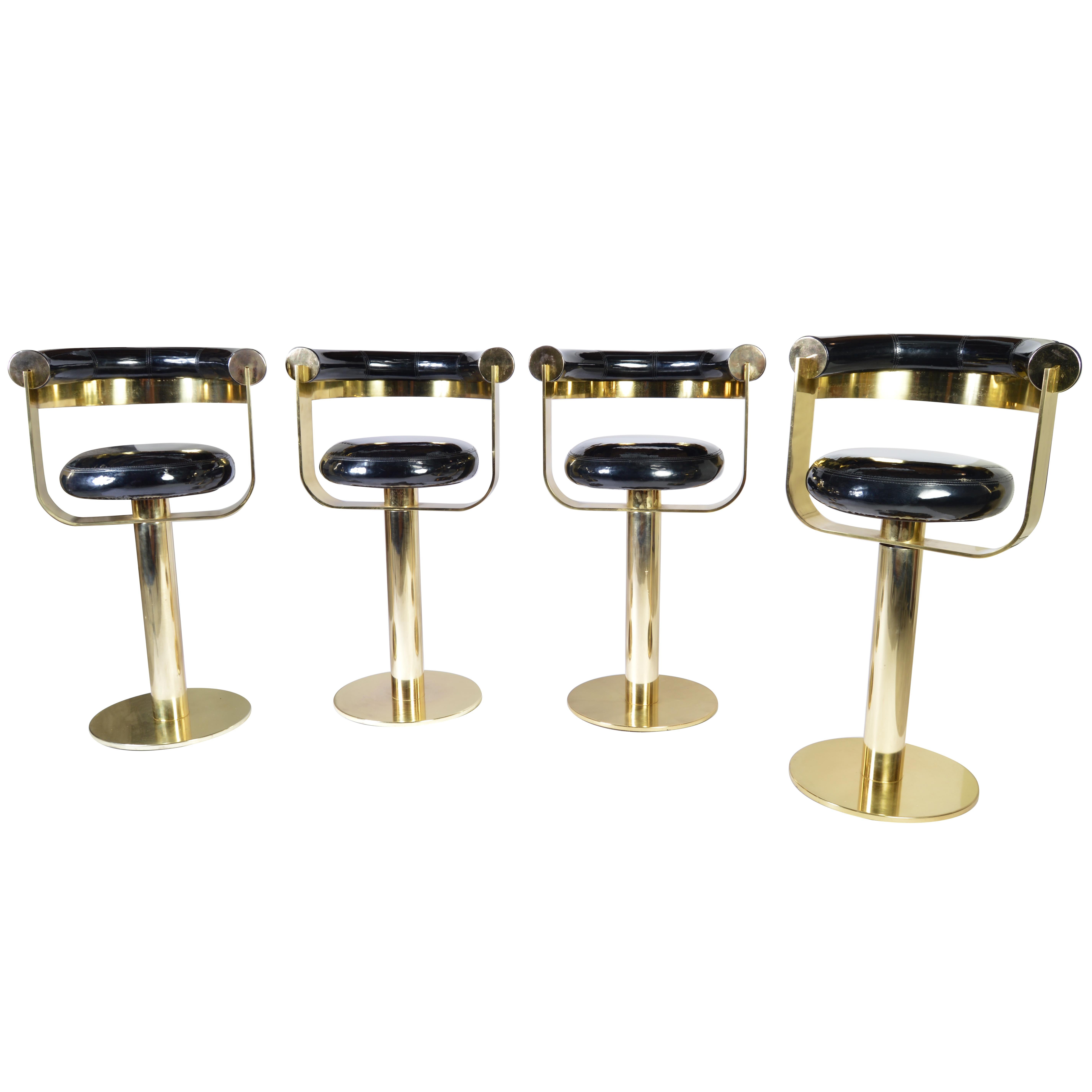 A set of 4 brass designer counter bar stools custom designed in 1973 for an installation in Elkins Park, PA. In phenomenal vintage condition having high gloss vinyl seats, polished brass frames with silent 360 pivoting motion. Each stool is
