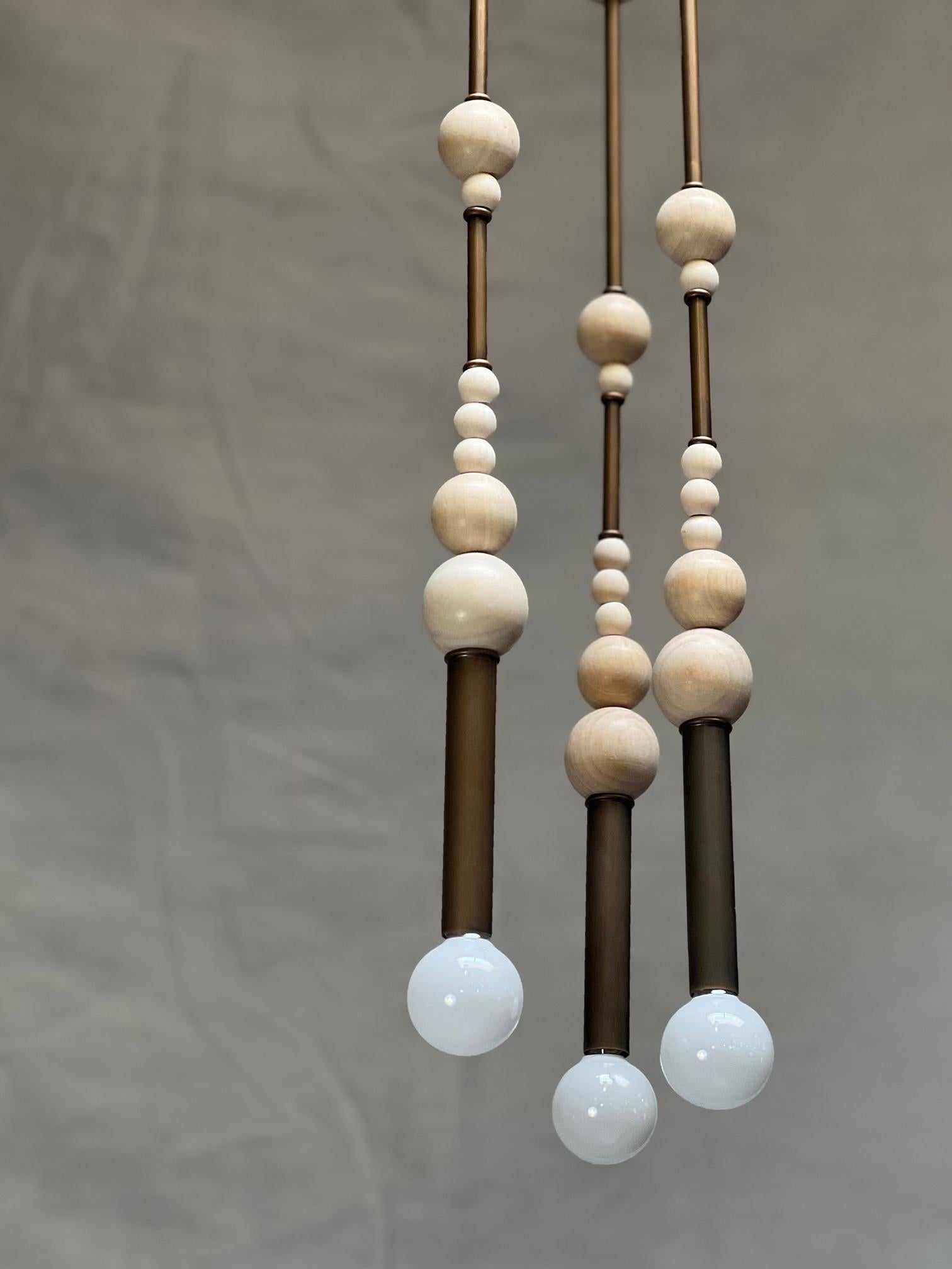 Very unique set of three, four foot pendants. Built with an artistic assembly of multi sized wood beads stacked between 3/4