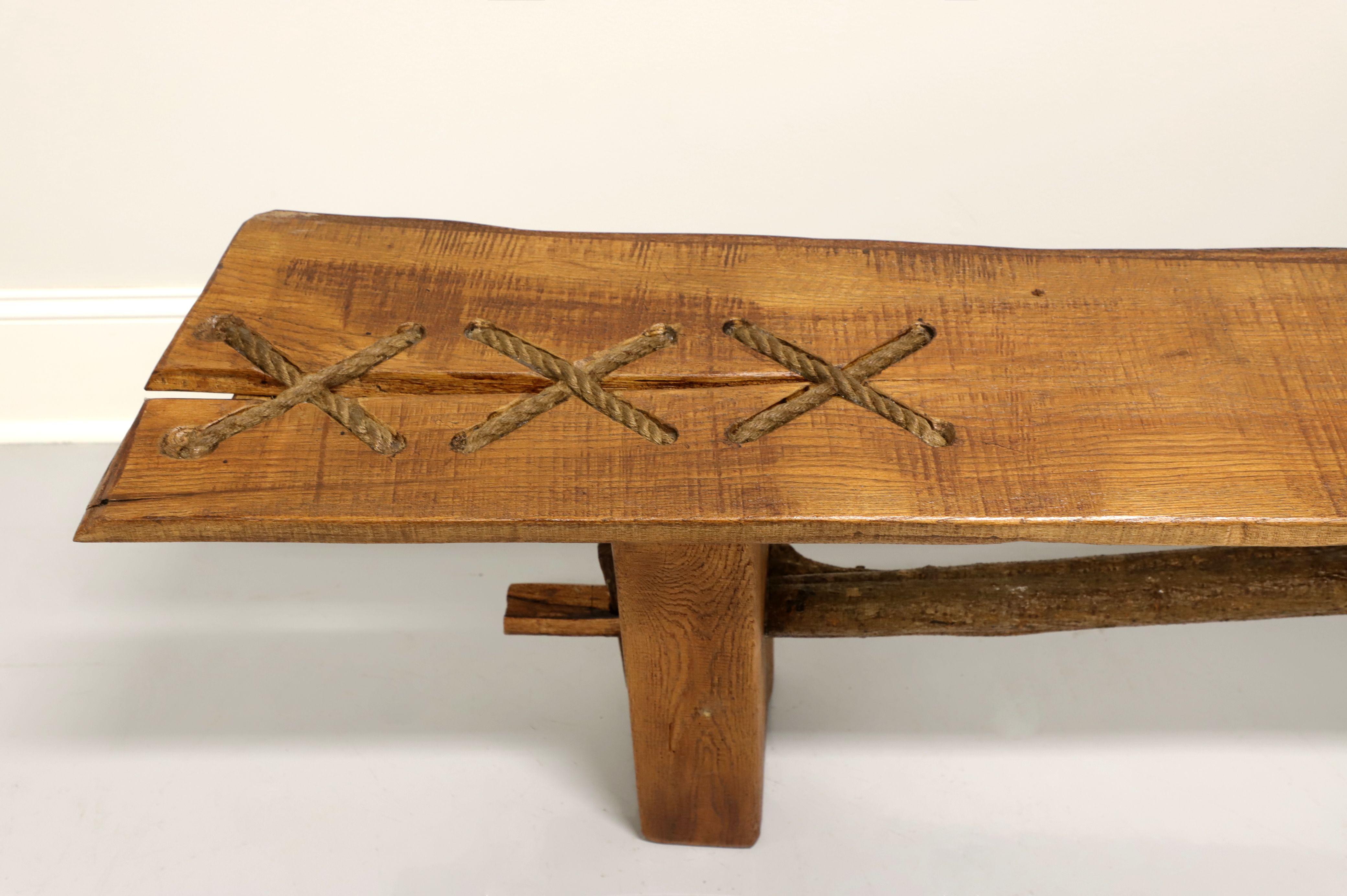 Un long banc de style rustique, de 90 pouces, fabriqué à la main par un artisan en Caroline du Nord, aux États-Unis. Bois dur massif brut de sciage avec bord vif, accents de corde lacée, base de rondin sculptée et brancard de rondin. Fabriqué au