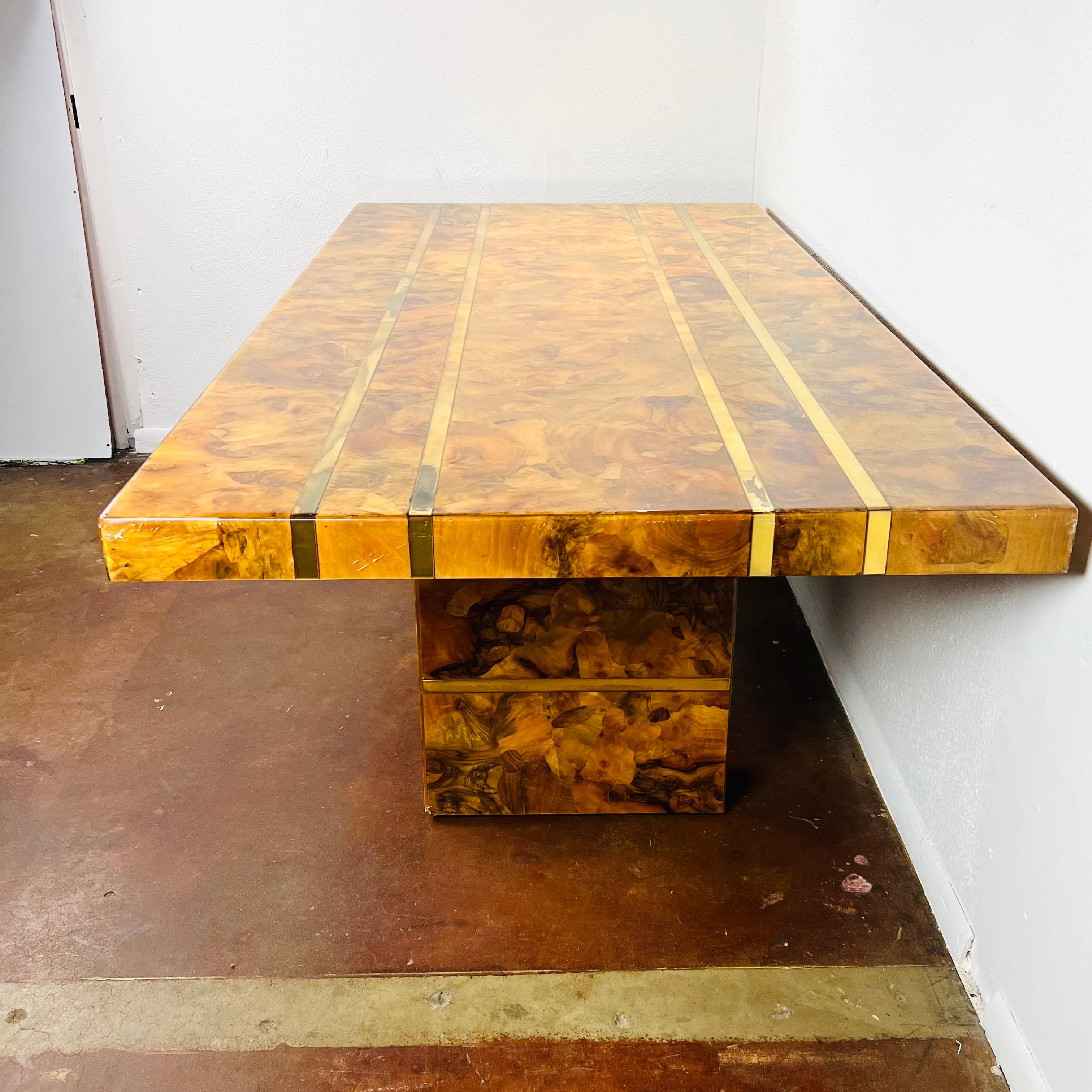 Extraordinary Mid-Century Modern burl wood dining table in the style of Milo Baughman. Features high gloss lacquer shine, brass accents, and double pedestal base. Custom made circa 1970. Some scratches, cracks, and chipping to lacquer coat at table