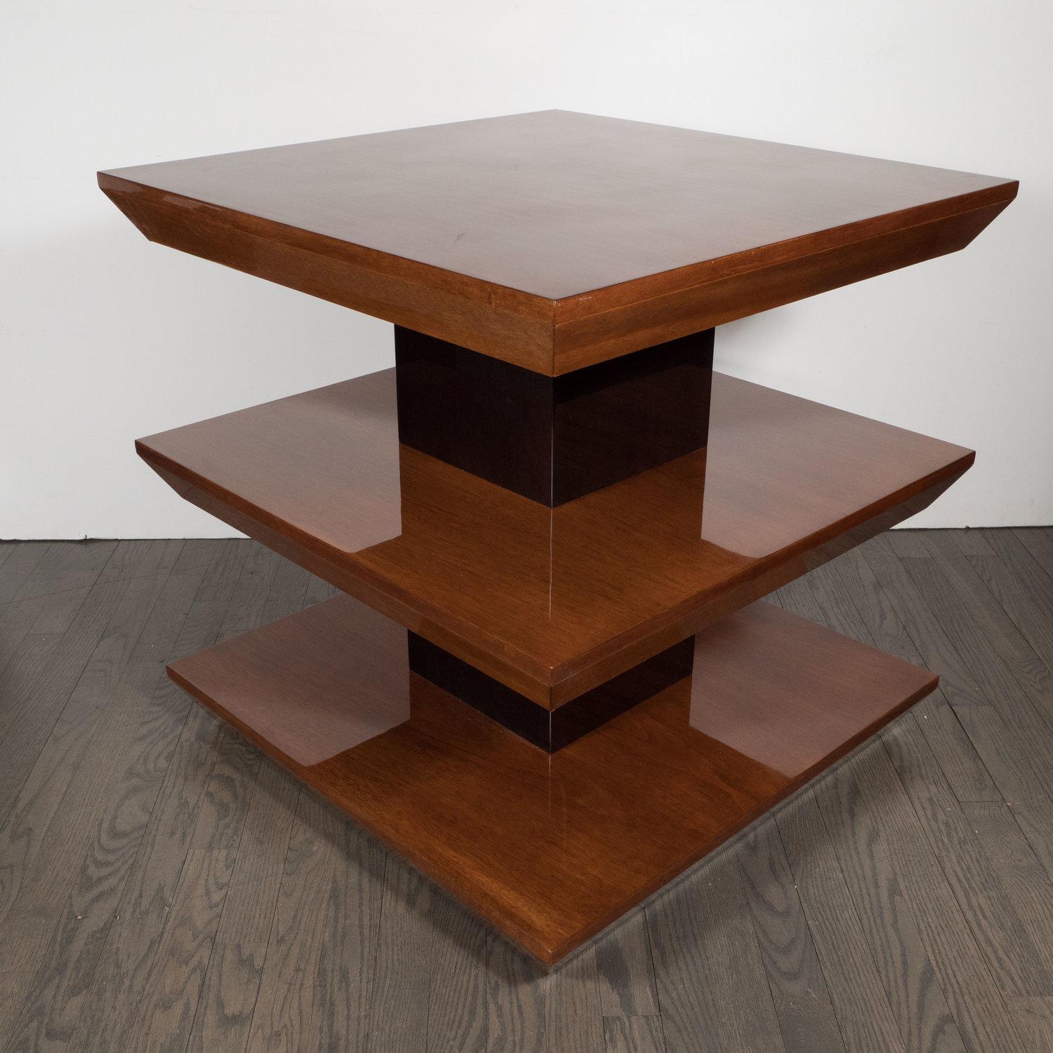This elegant skyscraper style side table was realized custom by High Style Deco in the 21st Century. It features three square tiers that recede downwards at angle from their squared off perimeters suggesting inverse pyramidal forms. The tops have