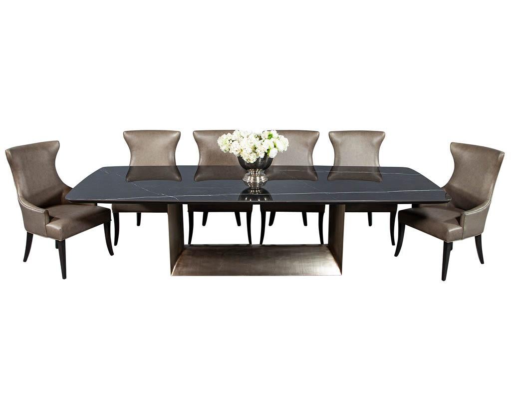 Carrocel custom made porcelain top dining table. Featuring a black lacquered tapered wood edge and rounded geometric antique champagne finished base. Chairs and vase not included*
Price includes complimentary curb side delivery to the continental