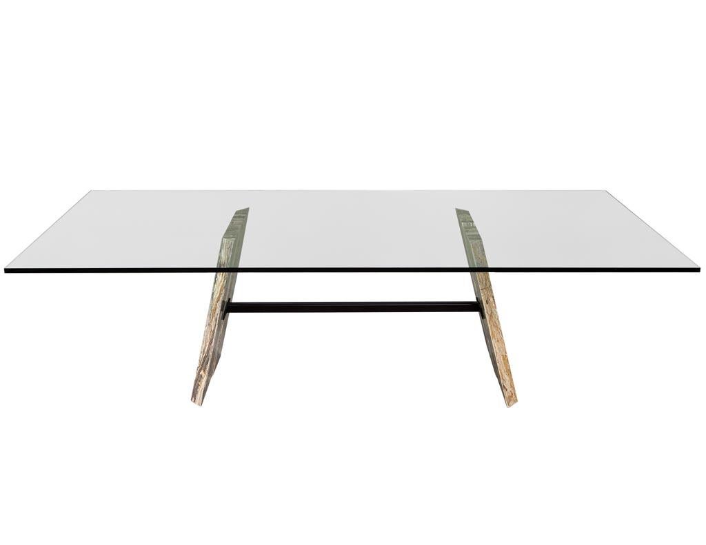 Custom cantilever stone base glass top dining table. Exclusive dining table with four Breccia Onicata slabs cantilevered with a bronzed span and glass top.

This table is custom and made to order with a lead time of 8-12 weeks plus shipping