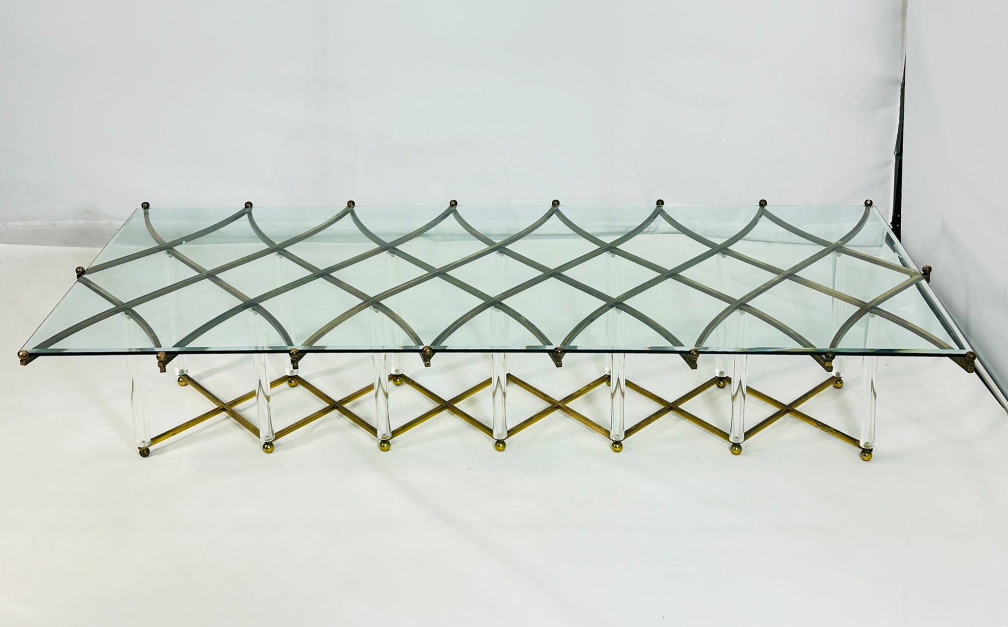 Cette étonnante table basse en laiton et en lucite de Hollis Jones est sans doute sa création la plus exquise. 
Connu pour ses innovations dans l'utilisation de la Lucite et du métal, Eleg Jones est passé maître dans l'art d'allier élégance et