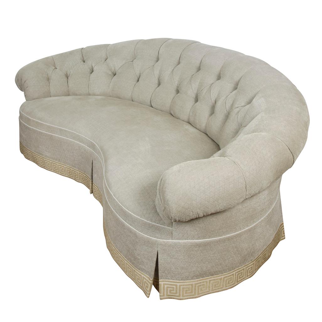 Custom chenille, kidney shaped, tufted sofa in grey with greek key ivory trim.