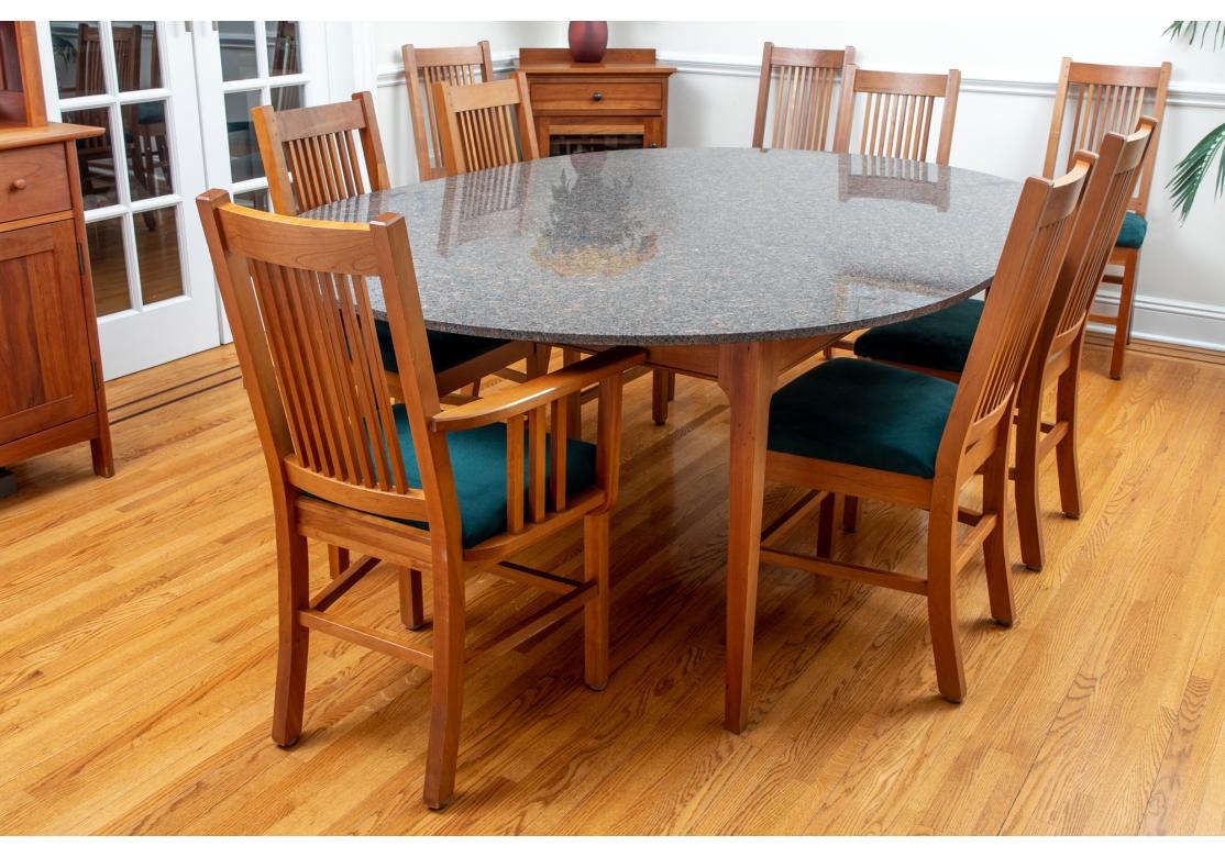 A very well made custom New Haven Woodworks arts & crafts style oval cherry wood table with square tapering legs and covered with a granite top. The table is accompanied by 2 arm chairs and 8 side chairs with vertical slats, upholstered seats,