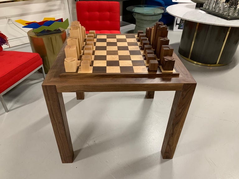 A custom made walnut and maple chess set and game table we commissioned. It is solidly made with squares of curly maple and walnut. The table legs and borders are solid walnut. The chess top flips with an oak veneer on the bottom. The pieces are