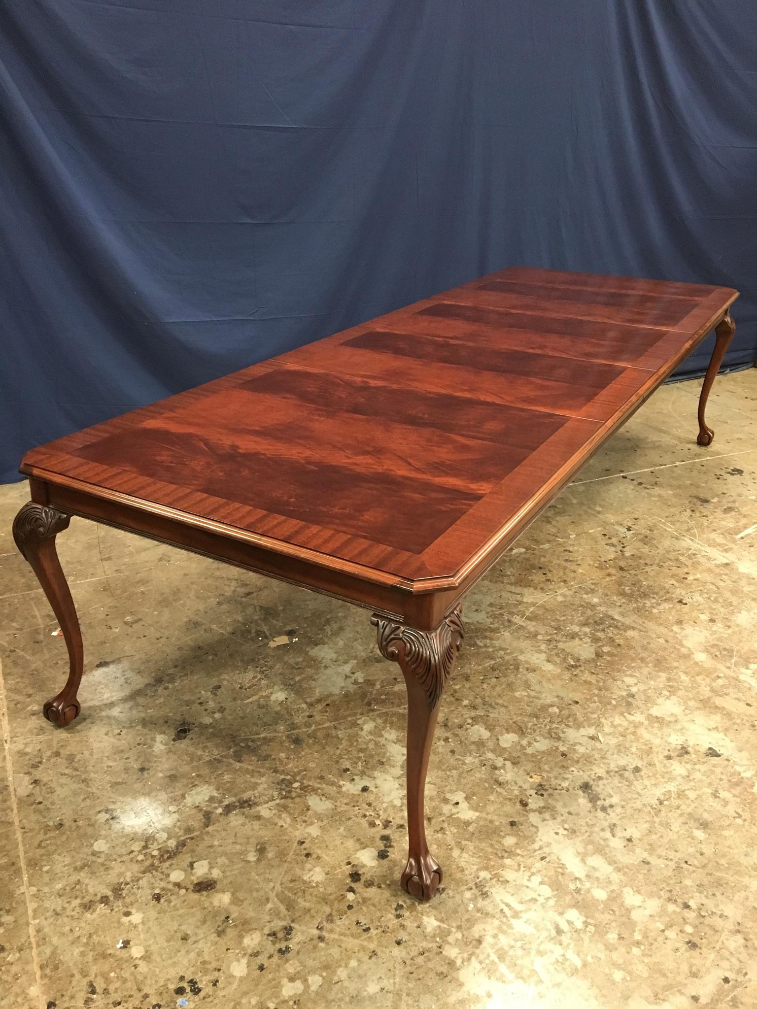 This is a made-to-order traditional Chippendale style ball and claw foot mahogany dining table made in the Leighton Hall shop. It features a field of reverse-slip-matched swirly crotch mahogany from West Africa and a straight grain mahogany border.