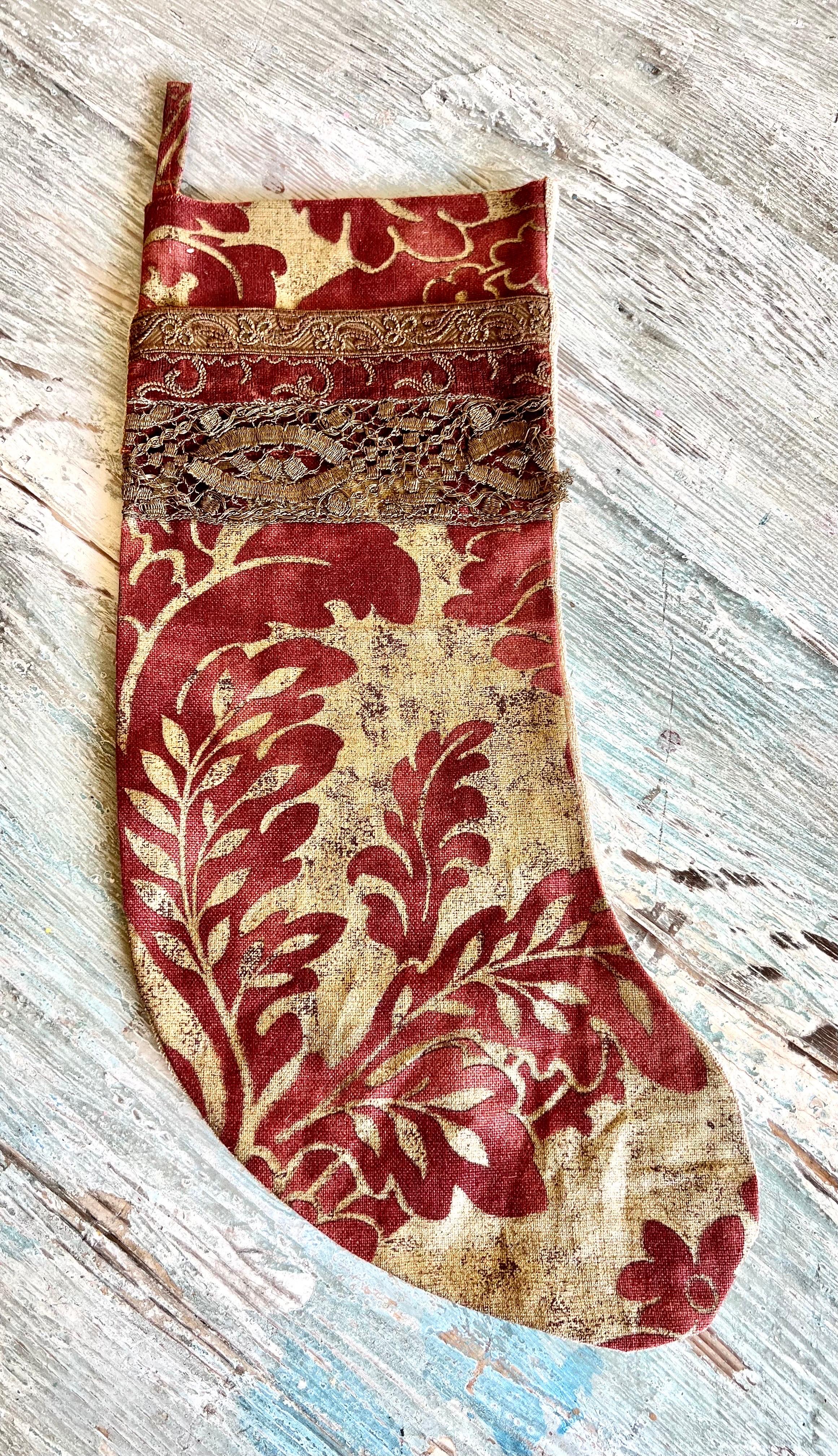 A Christmas stocking crafted from metallic gold and red damask textile, adorned with 19th century metallic trims, would exude a vintage charm and opulence to your Christmas decor.  The combination of rich colors and historical trims adds a touch of