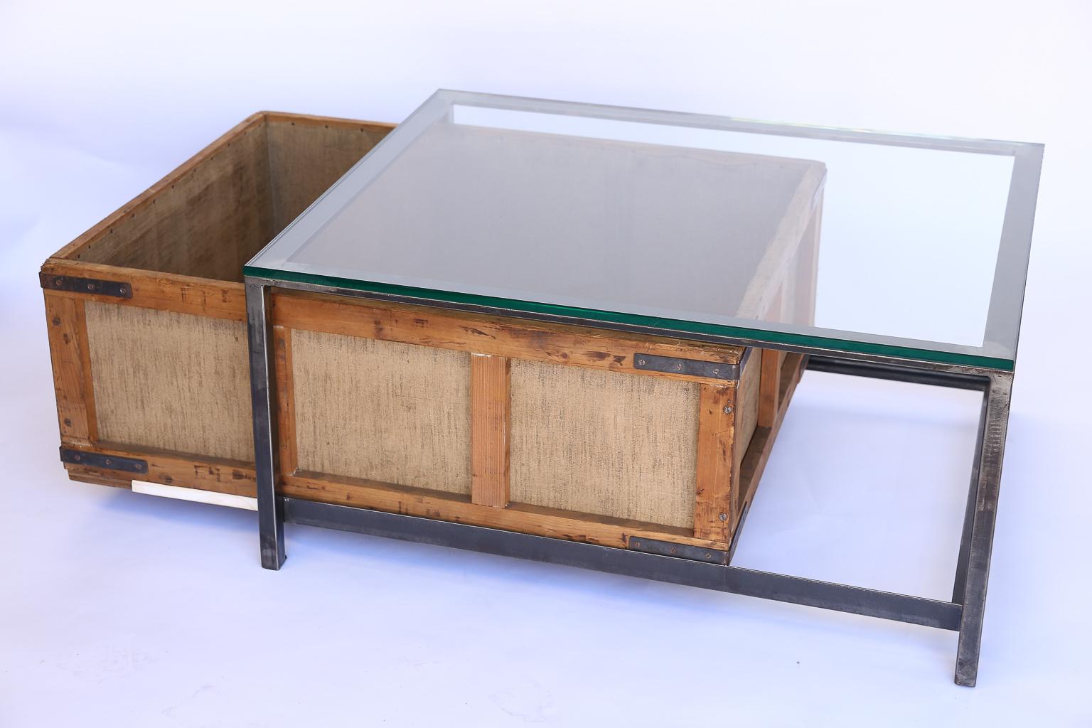 This is a custom coffee table made from a vintage German cigar storage bin. The bin was used to store cigars which were hand rolled in a German cigar factory. The table features new glass and iron which form the coffee table. The cigar bin adds
