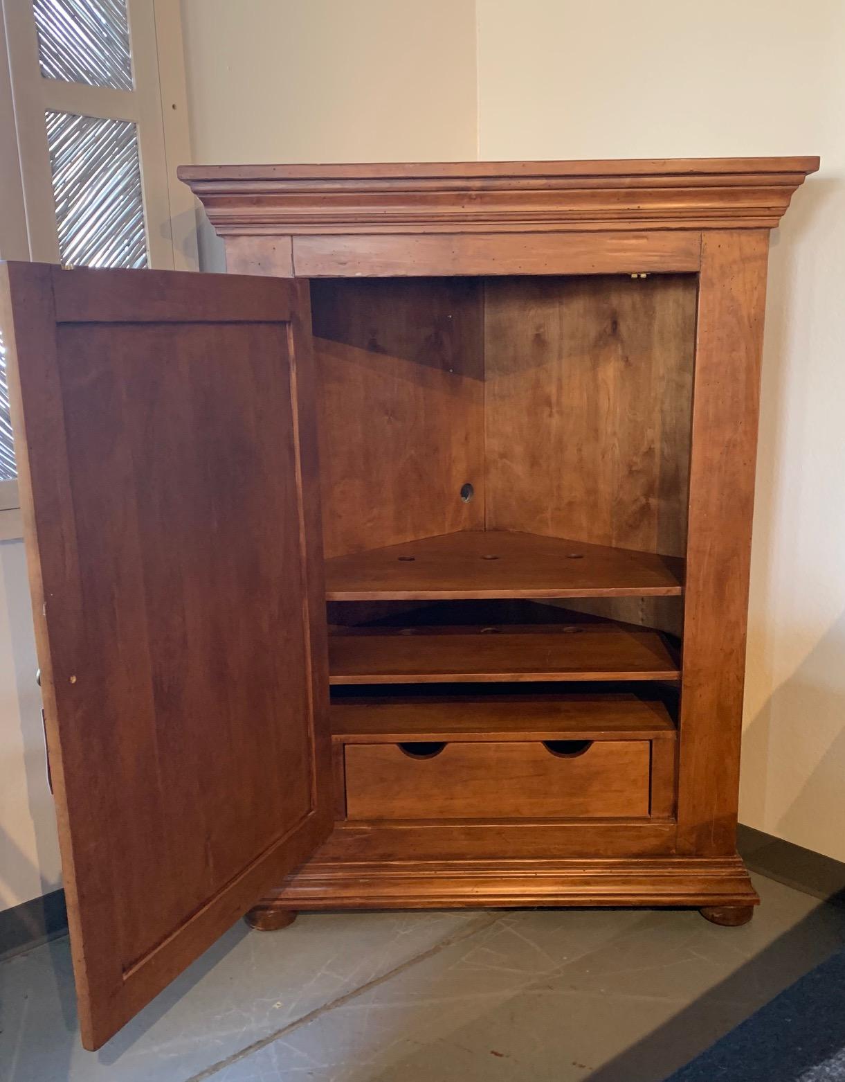 This Ernest Thompson Legacy Collection Custom Corner Cabinet is made in Knotty Alder with a custom finish. Beautifully handcrafted and distressed. There are three shelves and one drawer in the interior.