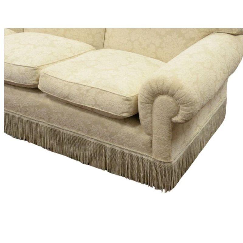 A custom De Angelis sofa in cream textured damask fabric. A blend of sophistication and comfort, the three-seat roll arm design is adorned with a sumptuous upholstery. This textured fabric adds an inviting feel to the touch, adding to the overall