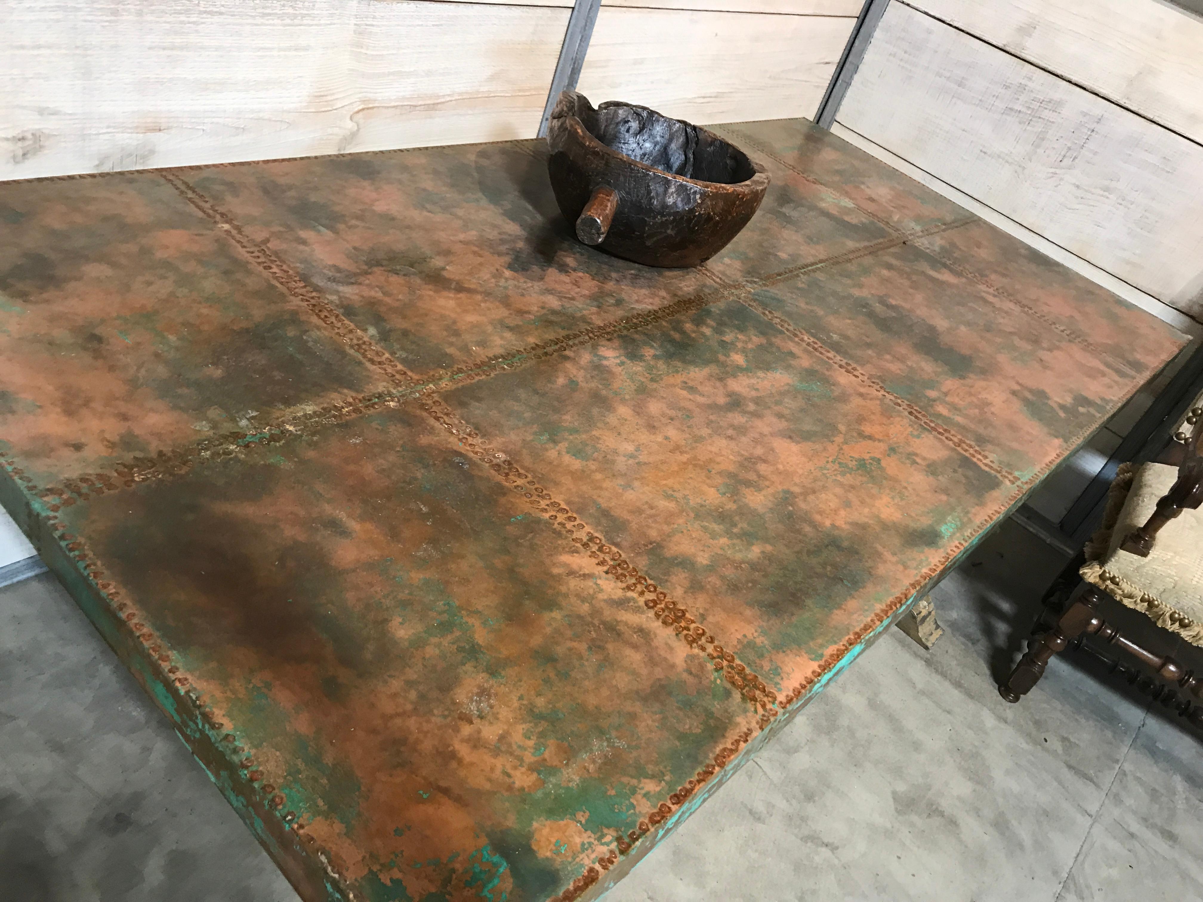 Top paneled in copper with a green “verdigris“ patination and 2000 hand-hammered nails. Trestle Base made of cedar with four chamfered uprights and central stretcher. All with distressed painted finish. This table designed and custom made by