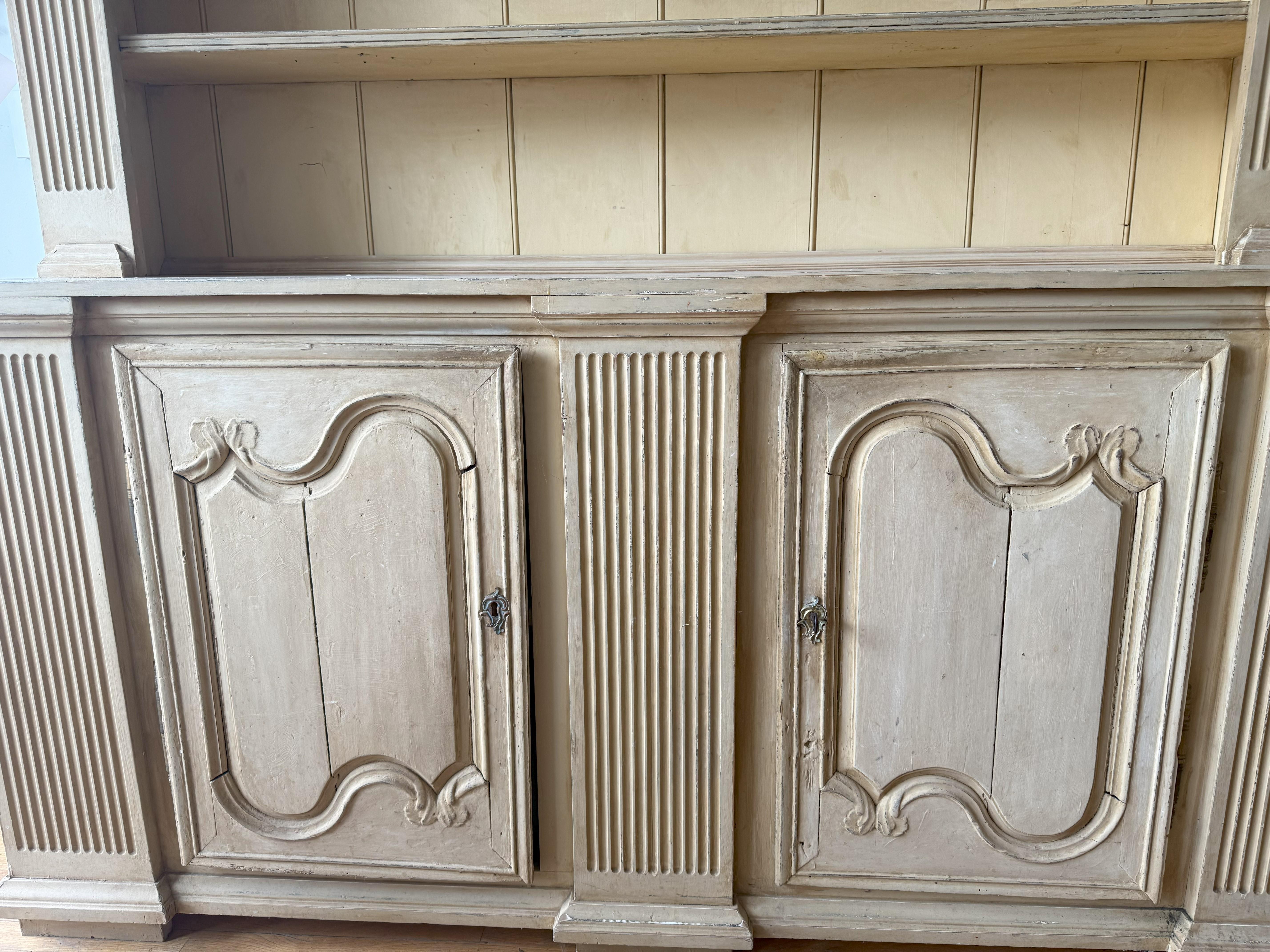 Vaisselier francese provenzale in stile Luigi XV progettato su misura. Si tratta di una credenza in due parti utilizzata per esporre le porcellane e gli utensili da cucina. Questo esemplare è stato progettato attorno a due porte modanate del XVIII