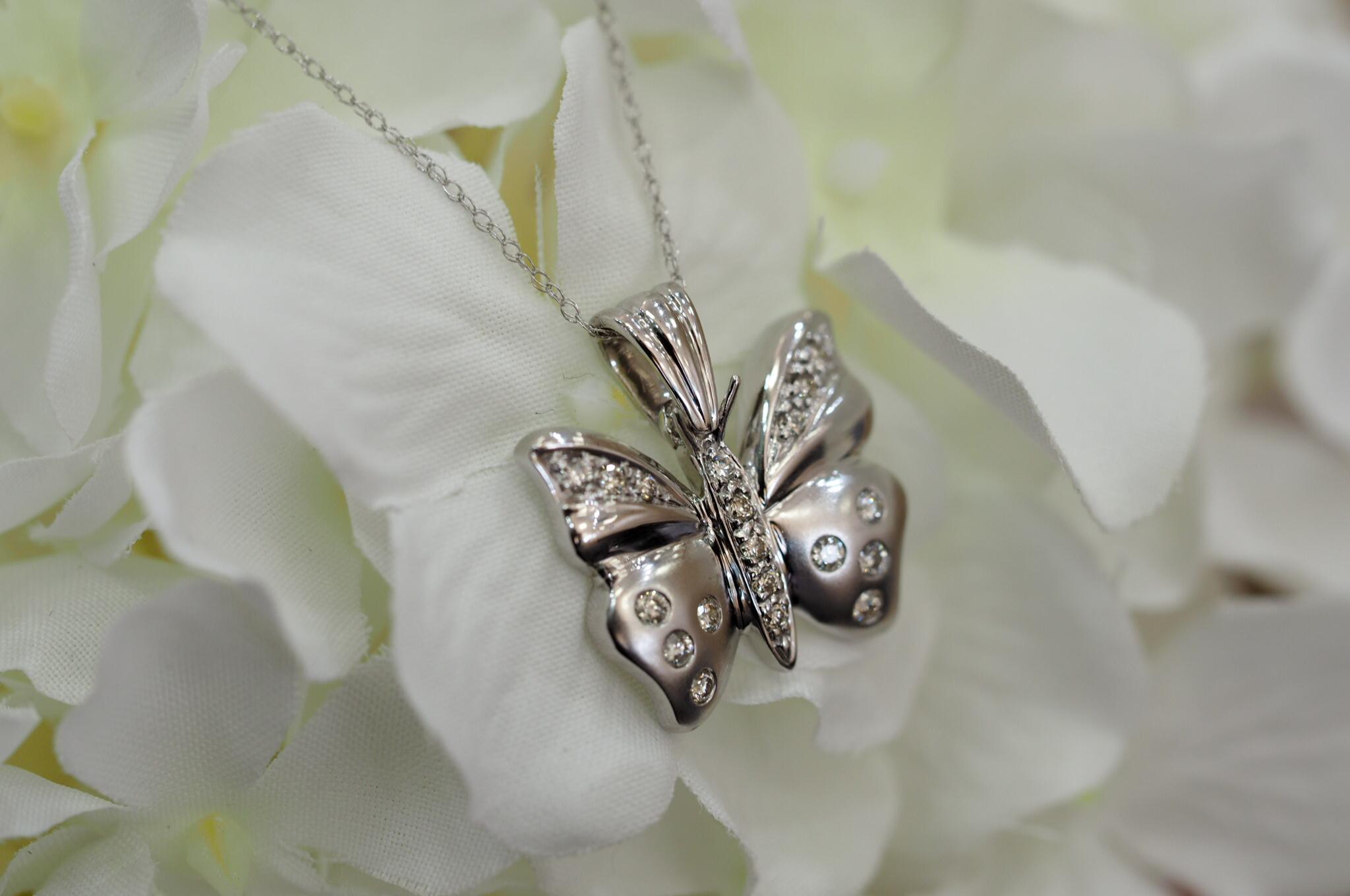 Magnifique pendentif papillon en or blanc 14K avec 0.25ctw de diamants ronds accentuant les ailes du papillon parfaitement avec sur une  collier à maillons câblés de 16 pouces.
