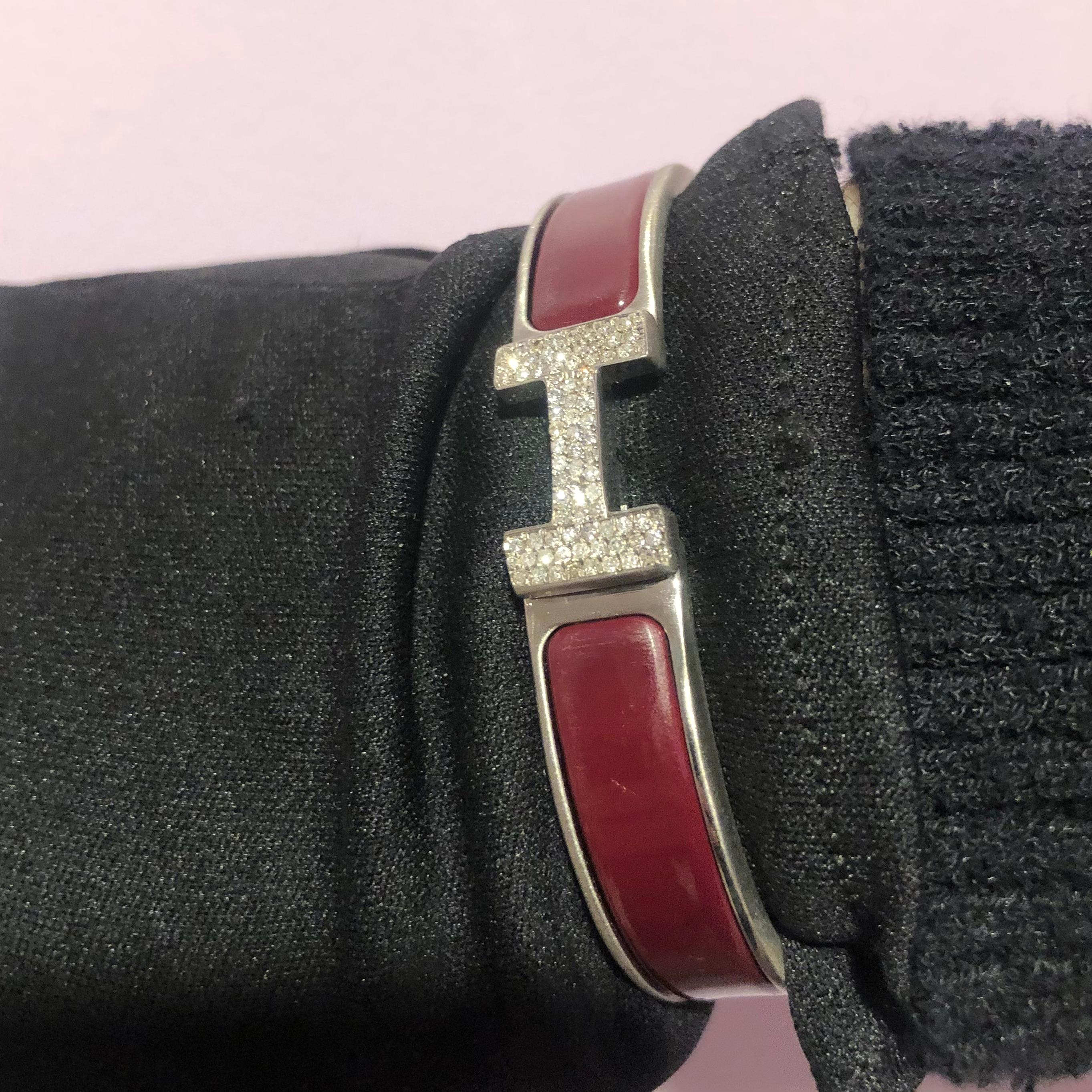 Bracelet Hermes Clic H avec diamants sur mesure, complet avec boîte d'origine.

Un bracelet Hermes Clic H taille GM en rouge et argent est serti à la main d'environ 1,25 carats de diamants naturels SI-I d'origine minière. Les diamants brillent de