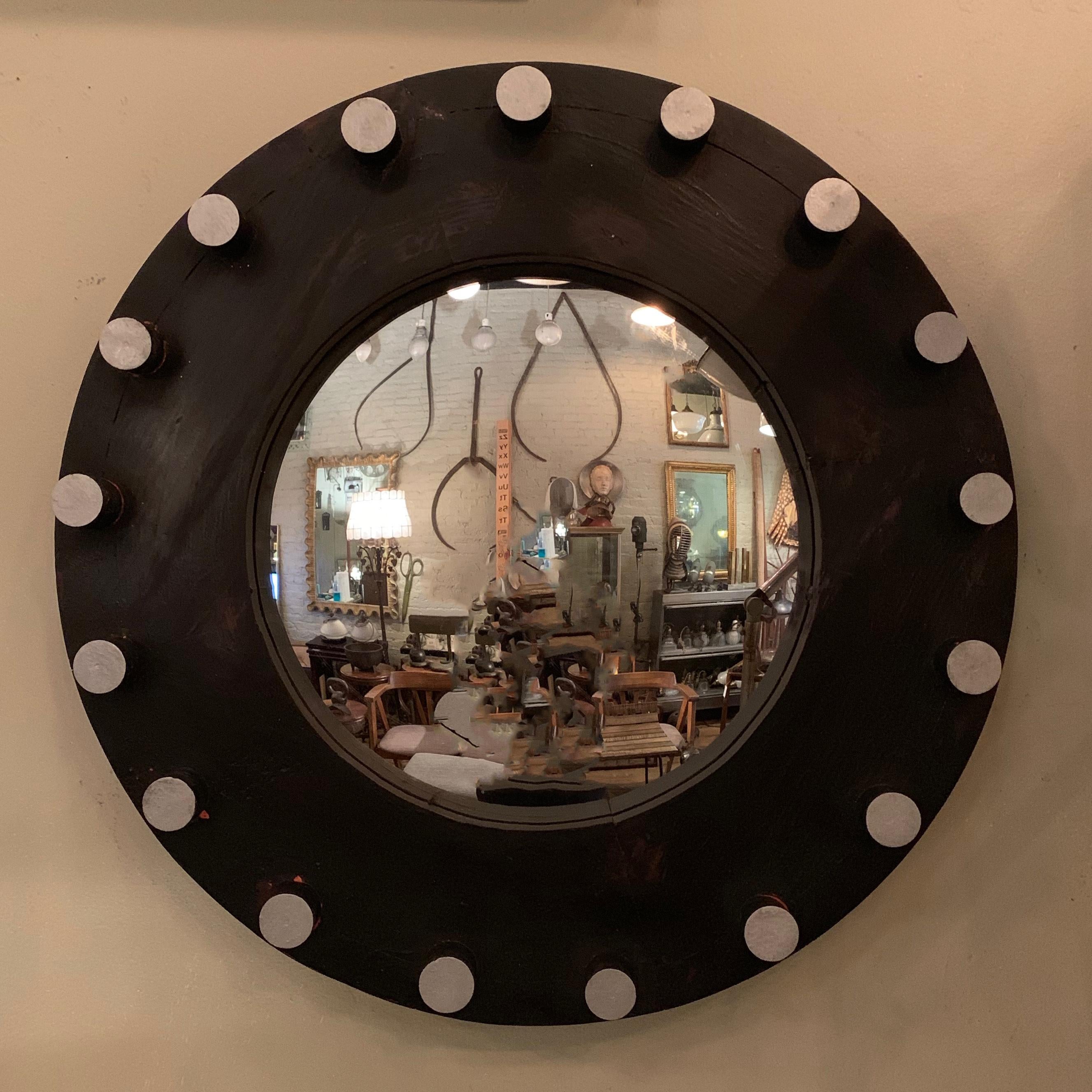 Custom, industrial, mirror features a round, ebonized pine, foundry pattern frame with silver tipped dowels and a 12 inches diameter convex mirror.