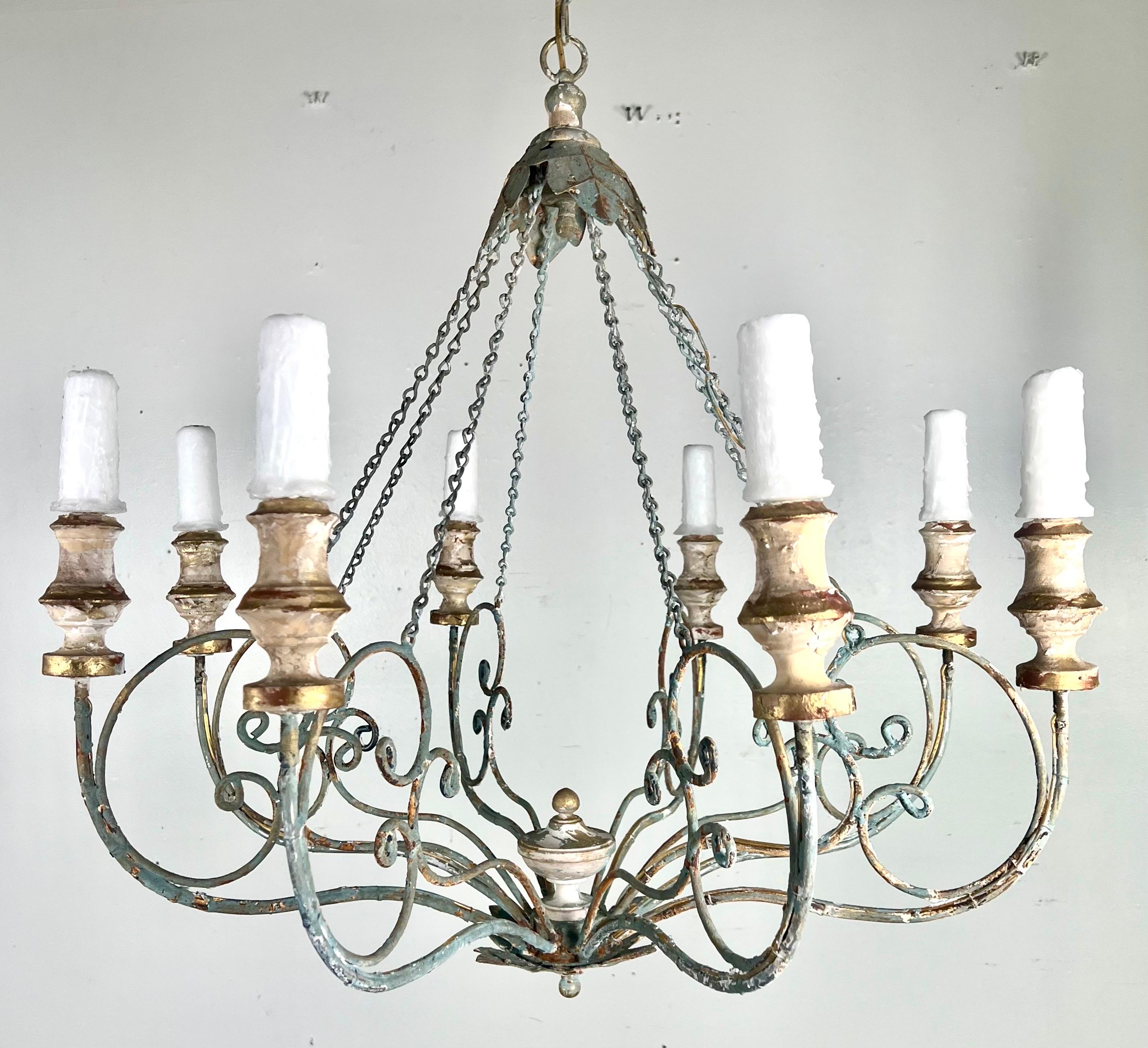 Eight arm painted iron & wood Melissa Levinson chandelier.  The iron is beautifully scrolled with wood painted bobeches.  The paint is purposely weathered to perfection.  The fixture is newly rewired and includes chain & canopy.  Drip wax candle