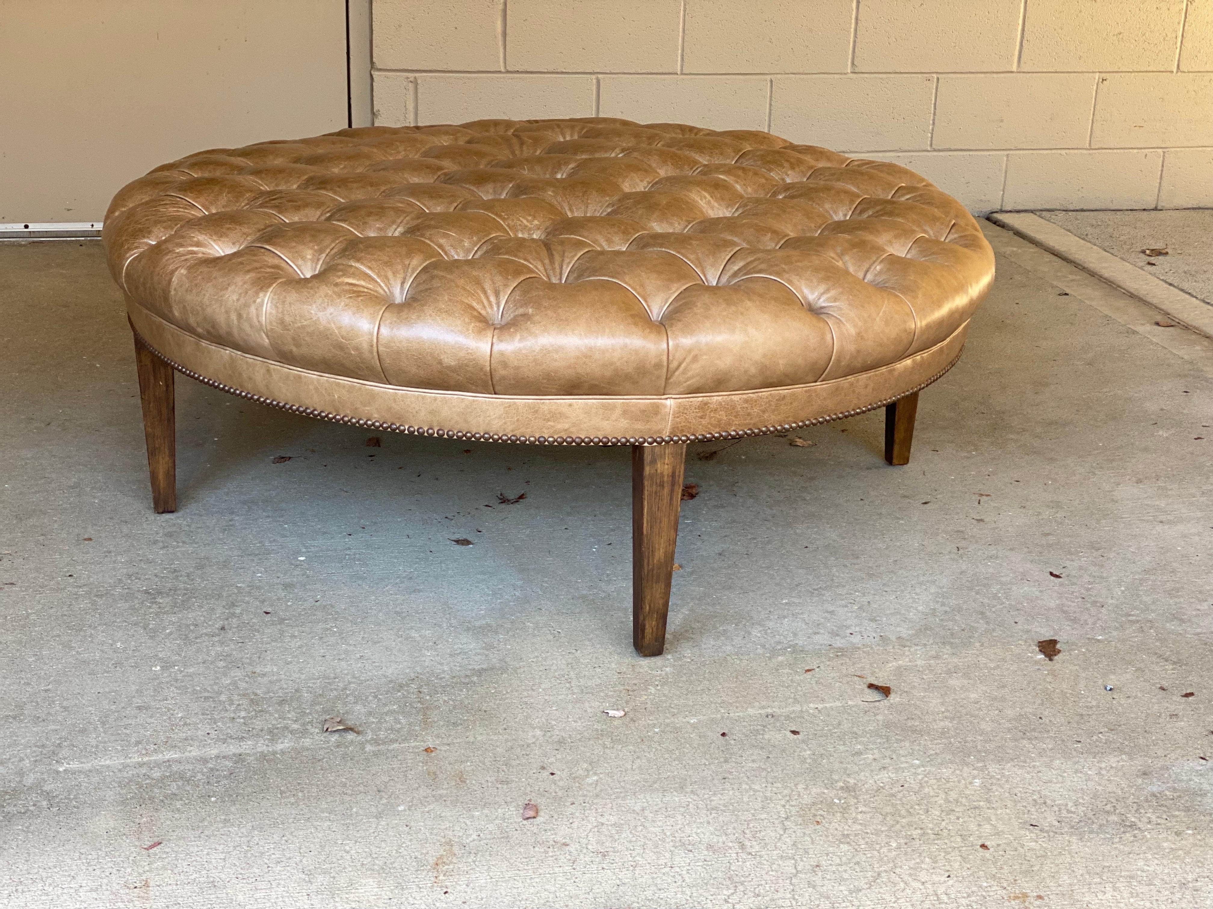 Custom Fabricated large round leather tufted ottoman/coffee table
A quality and well made solid wood ottoman with cerused oak legs and taupe tufted leather. This is a lovely piece, ready to go. Maker unknown but thought to have come from a