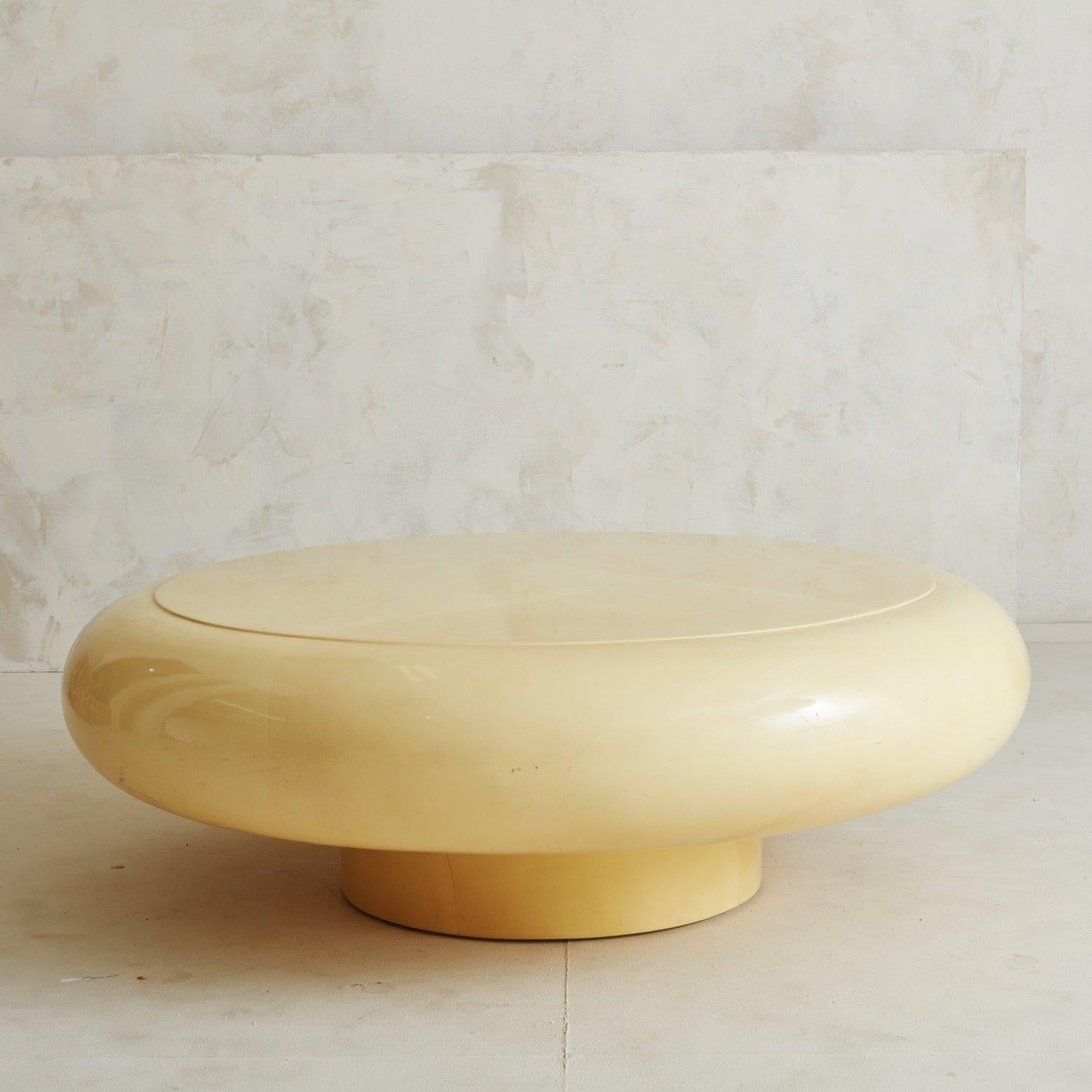 A custom mid-century round coffee table in a faux parchment lacquer finish. This sculptural table has a fabulous thick round top on a curved pedestal base. Sourced from the original owner.