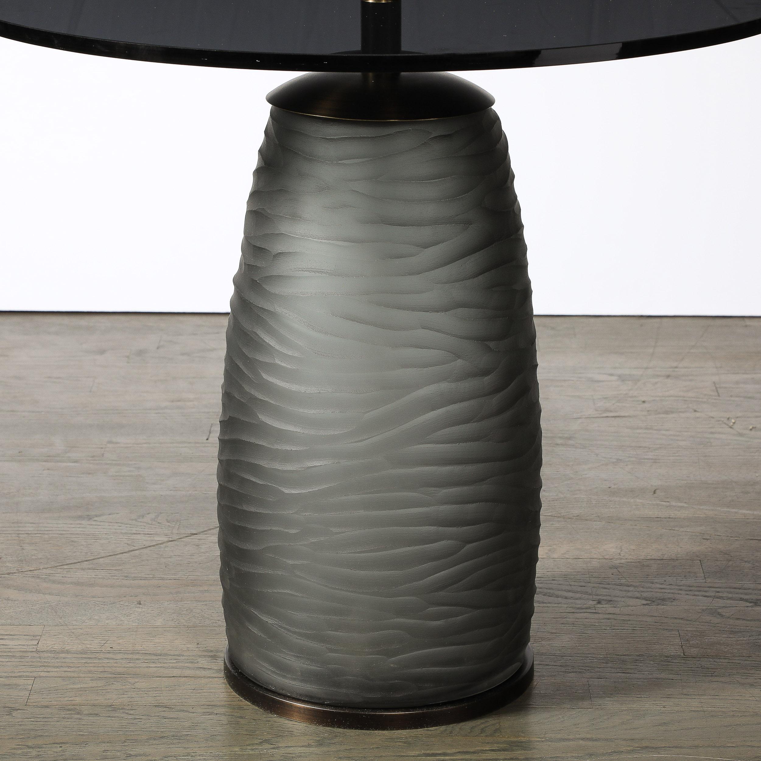 This striking and materially exquisite Modernist Hand-Blown Murano Smoked Battuto Glass Side/End Table with Oil Rubbed Bronze Fittings is Custom for High Style Deco and originates from Italy during the 21st Century. Features a round smoked glass top