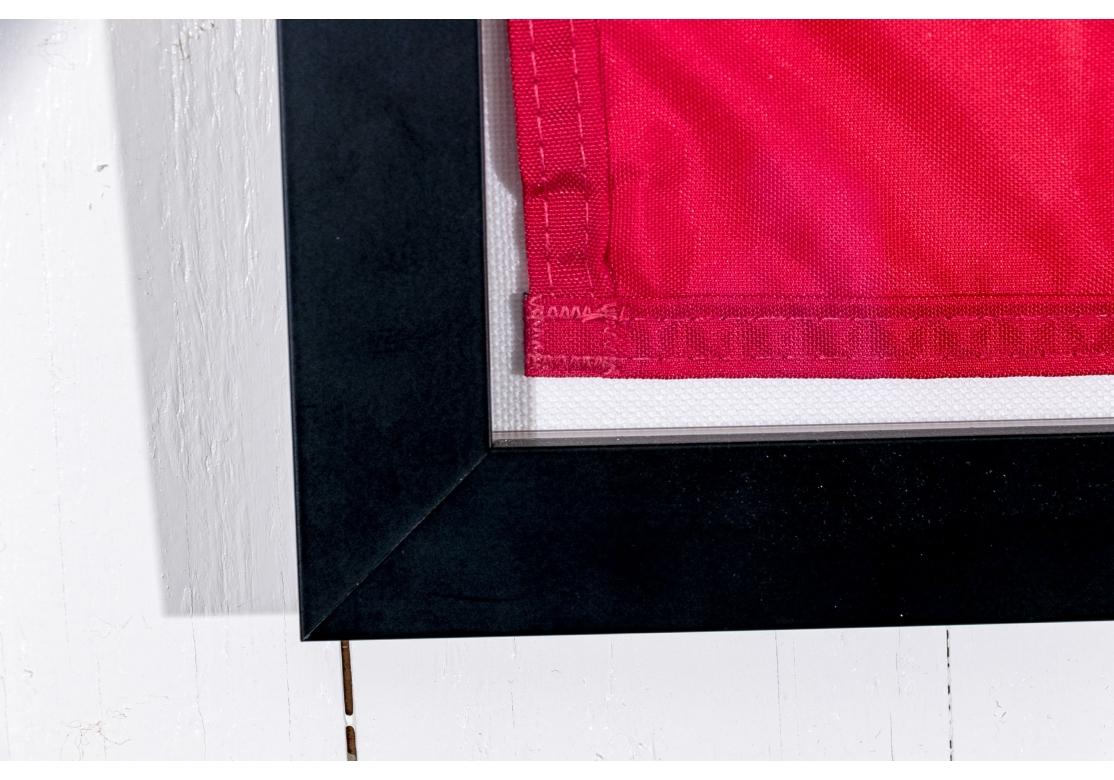Drapeau de Stratton Mountain Resort représentant une décalcomanie en vinyle formée d'une cartouche surmontée d'un champ en nylon rouge. L'autocollant noir avec le logo d'une patte d'ours. Présenté dans un cadre noir personnalisé et
