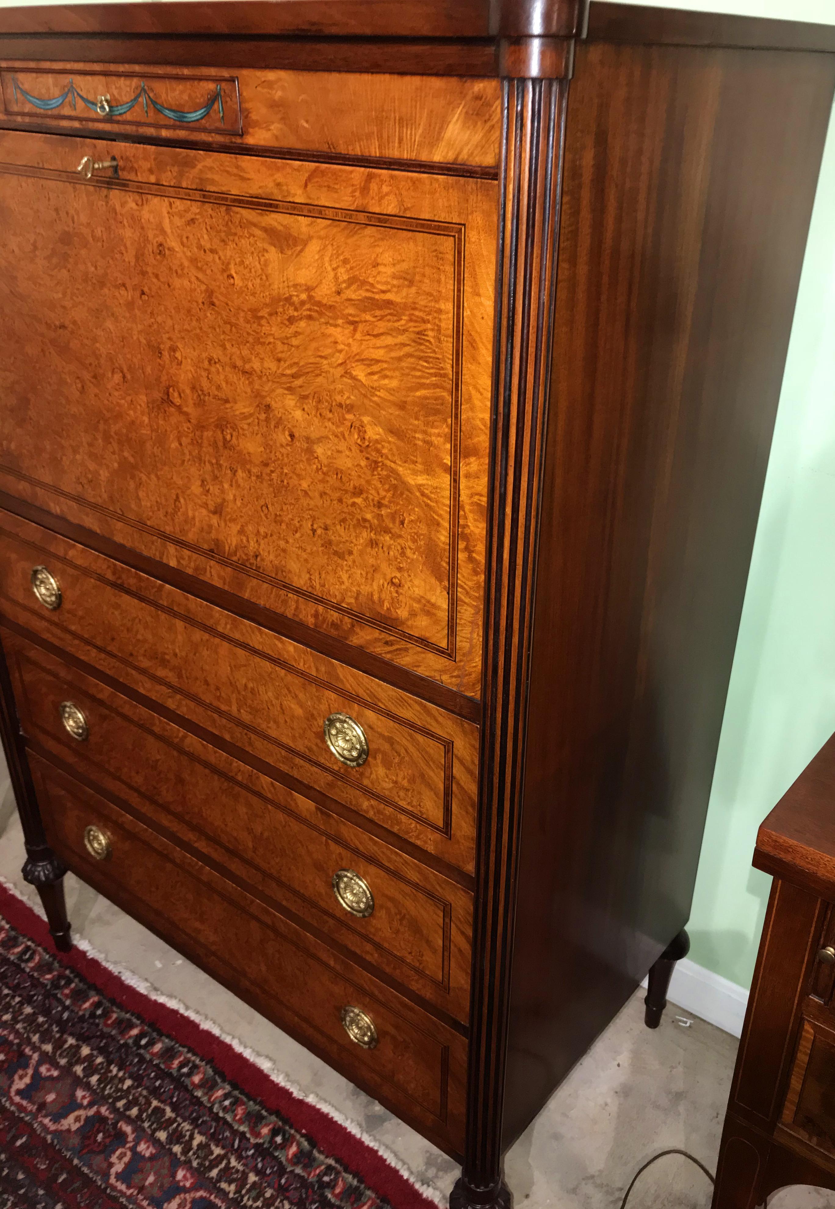 A fine custom gentleman’s tall chest in burled walnut veneer by Joseph Gerte, Boston. Drop down front, corner reeded columns, and finely carved legs. Dates to the mid-20th century in very good overall condition, with minor imperfections and light