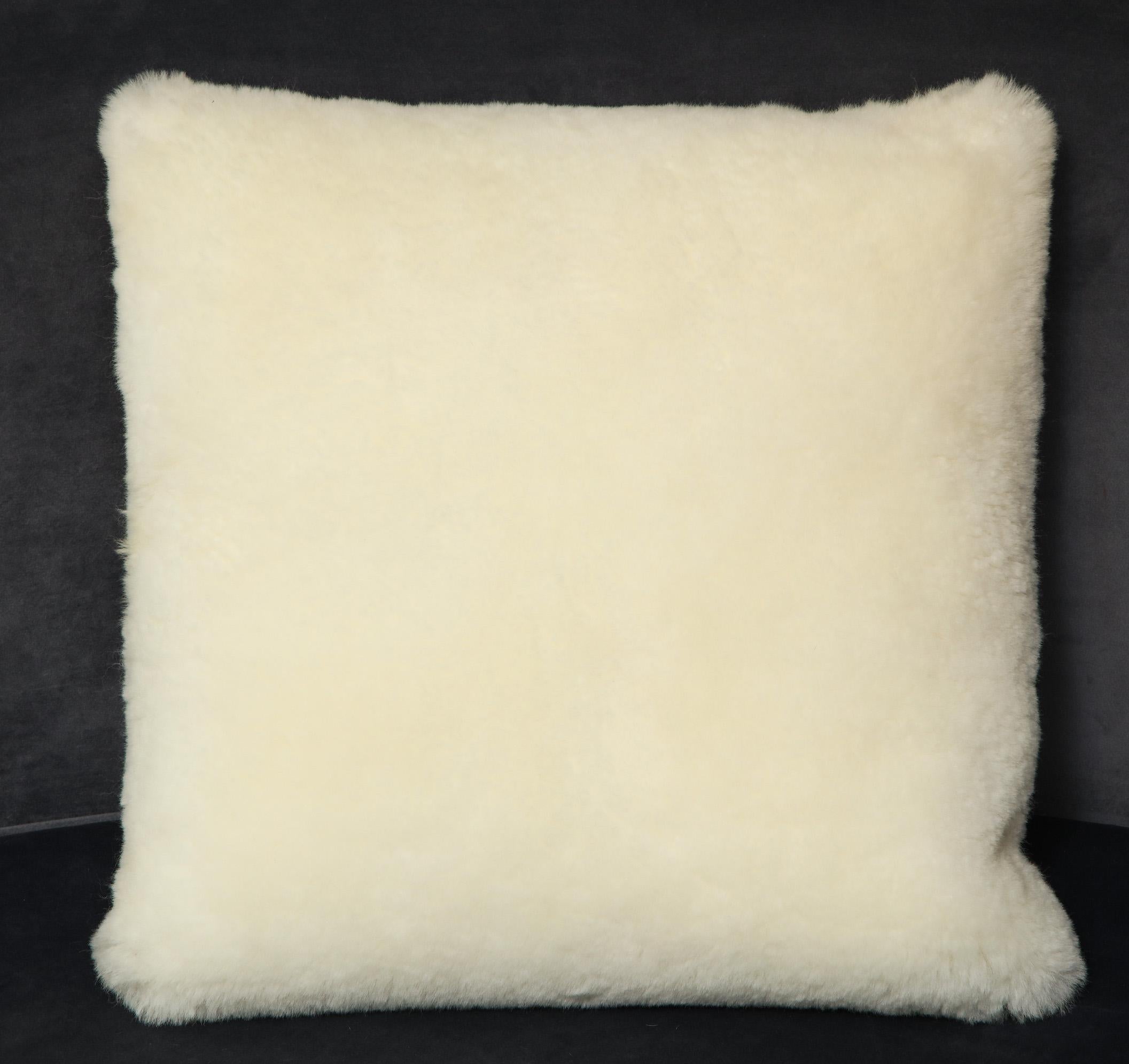 Coussin carré en peau de mouton de 45,72 cm de diamètre, fait sur mesure et de couleur crème. Des commandes personnalisées sont disponibles pour différentes tailles et couleurs.