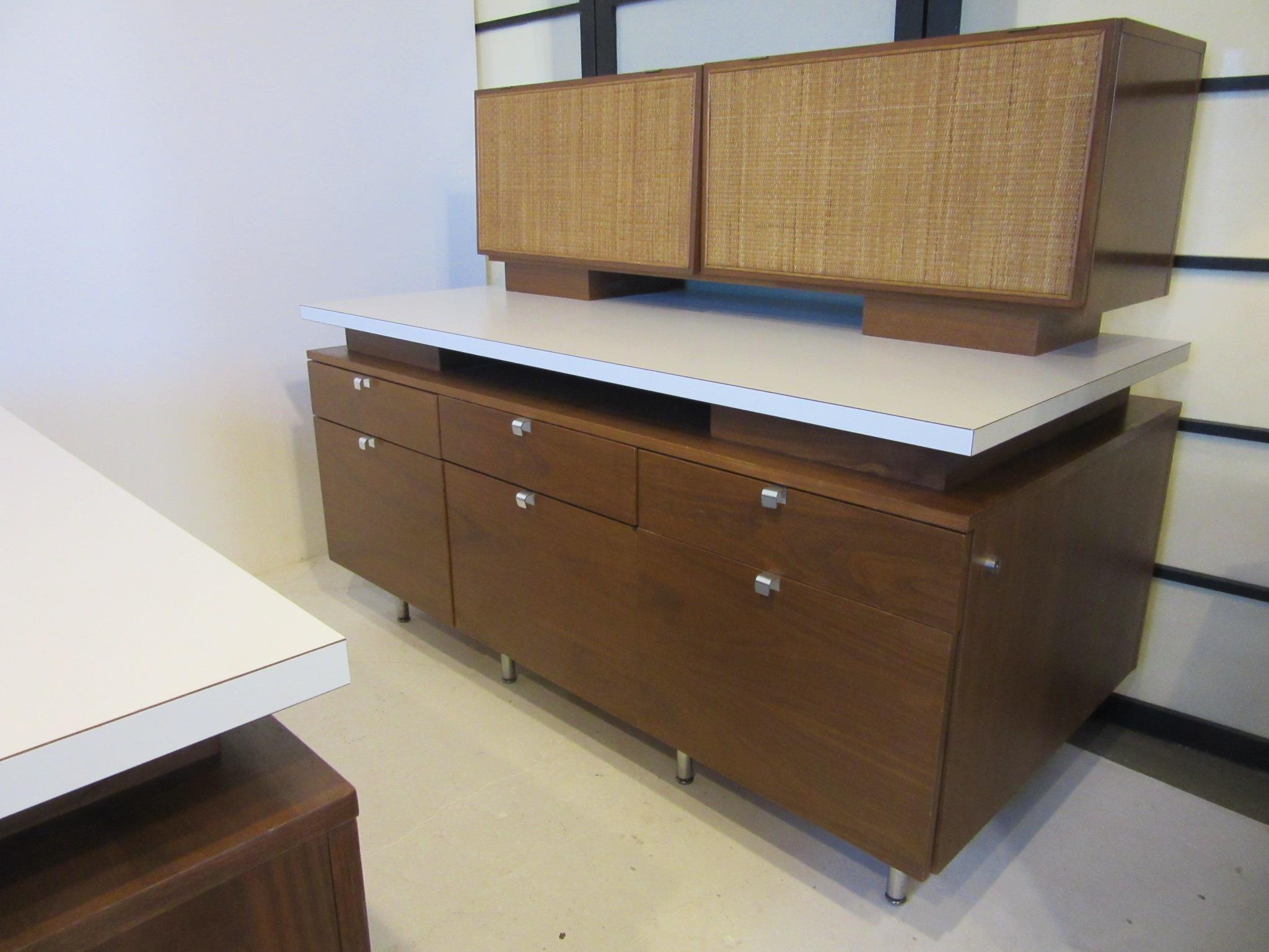 A rare Nelson walnut office styled hutch with work surface, two upper storage bins with caned flip up doors and three lower drawers and three lower files drawers. Custom made for the Irwin Union Bank building in Columbus Indiana which was designed