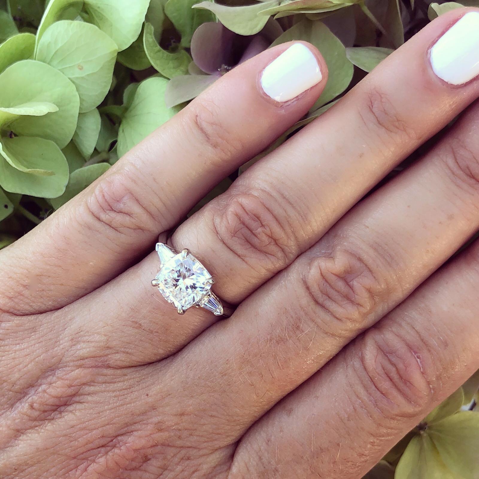 Exceptionally stunning 3.01 carat square-shaped cushion-cut diamond engagement ring, F color and VS1 clarity, set in a platinum mounting, with a bullet-shaped diamond on either side, with a 3.31 total weight for the ring. Unique and eye-catching!