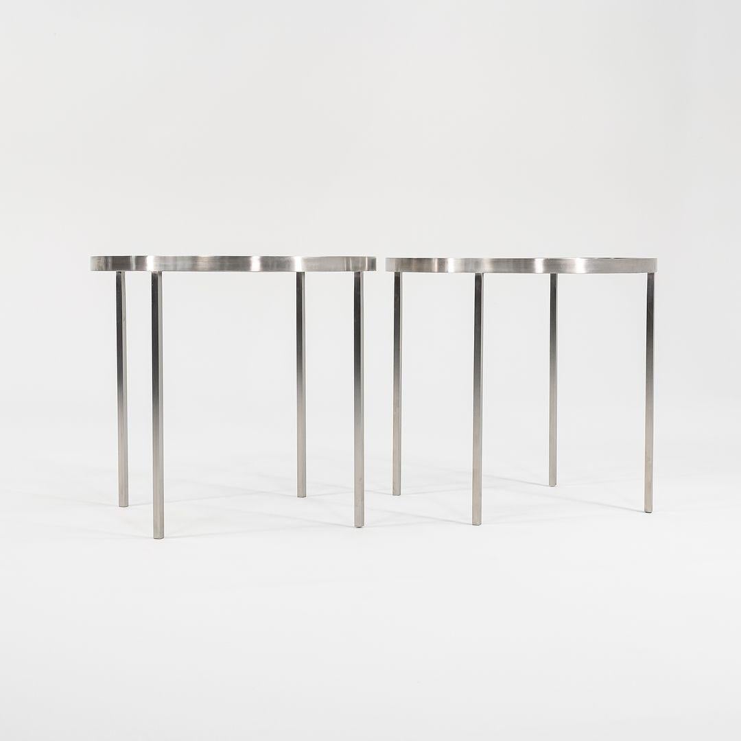 These are two (sold individually) custom solid stainless steel side tables by Gratz Industries. The tables were used as showroom models in Gratz's Philadelphia showroom and they appear to be in superb condition. The glass tops sit flush with the