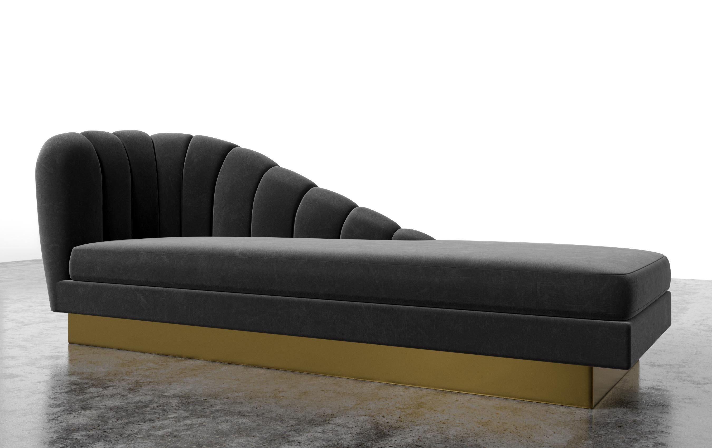 The Guinevere chaise, inspired by the curvature of Gaudi architecture, features an asymmetrical channeled scalloped slope that meets and rests over a layered metal plinth base. The custom size will be 76