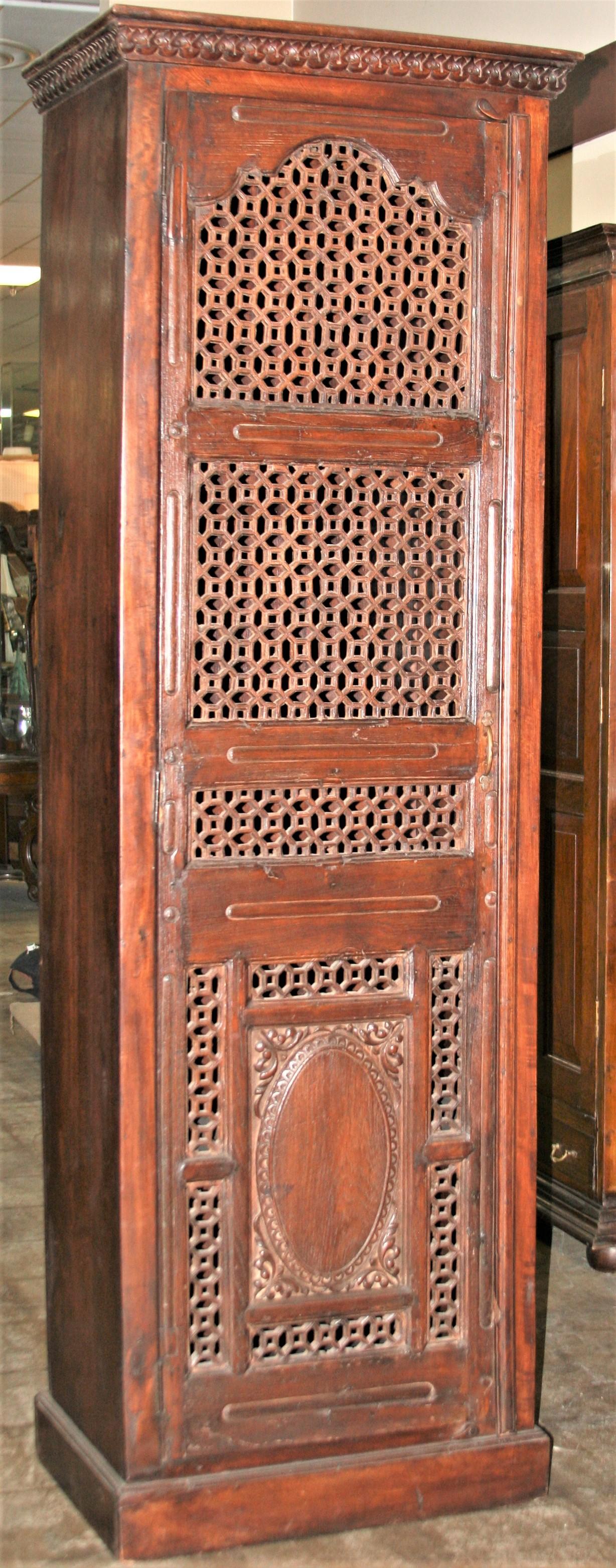 This cabinet is custom made by highly skilled artisans by using a hand picked decorative door from a 19th century home. This cabinet is made to last several generations. The teak wood door has elegant pierced carvings on the top and exceptional
