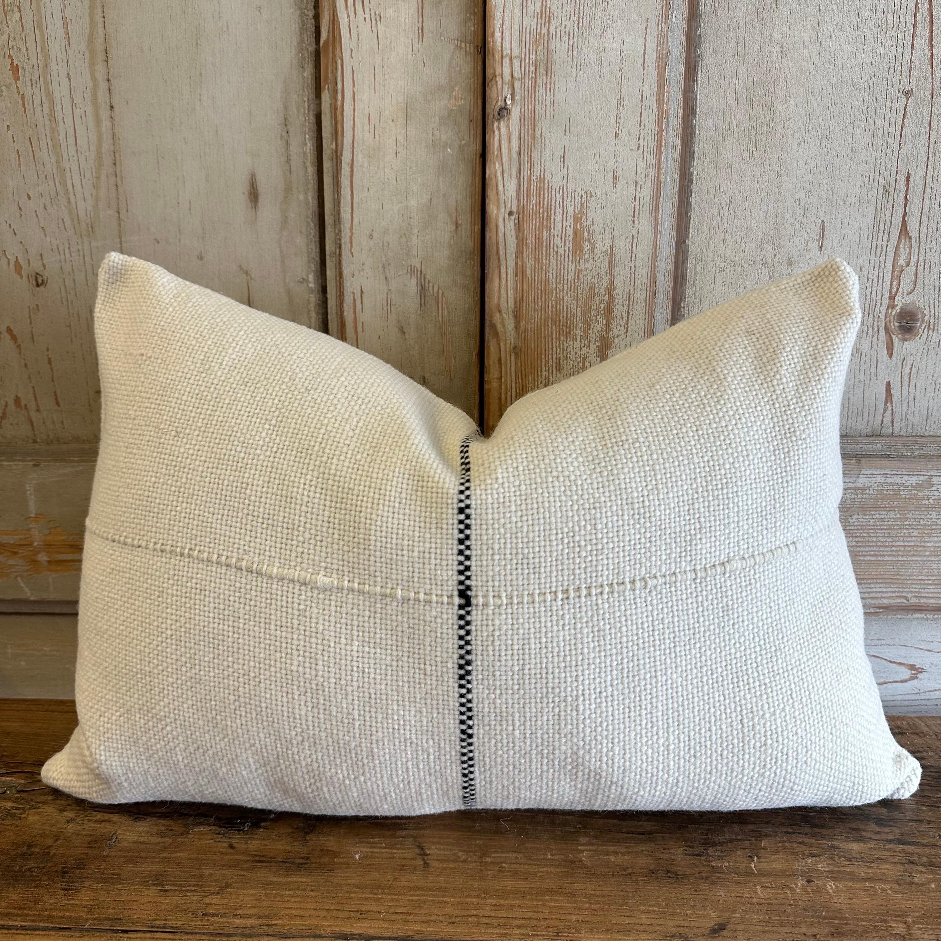 Wool Alpaca accent pillow from . A beautiful cream pillow with black stripe. Large wood yarns woven to create a beautiful texture. Hidden zipper closure. Due to the unique yarns, the color varies which are normal and to be expected. 
If this item