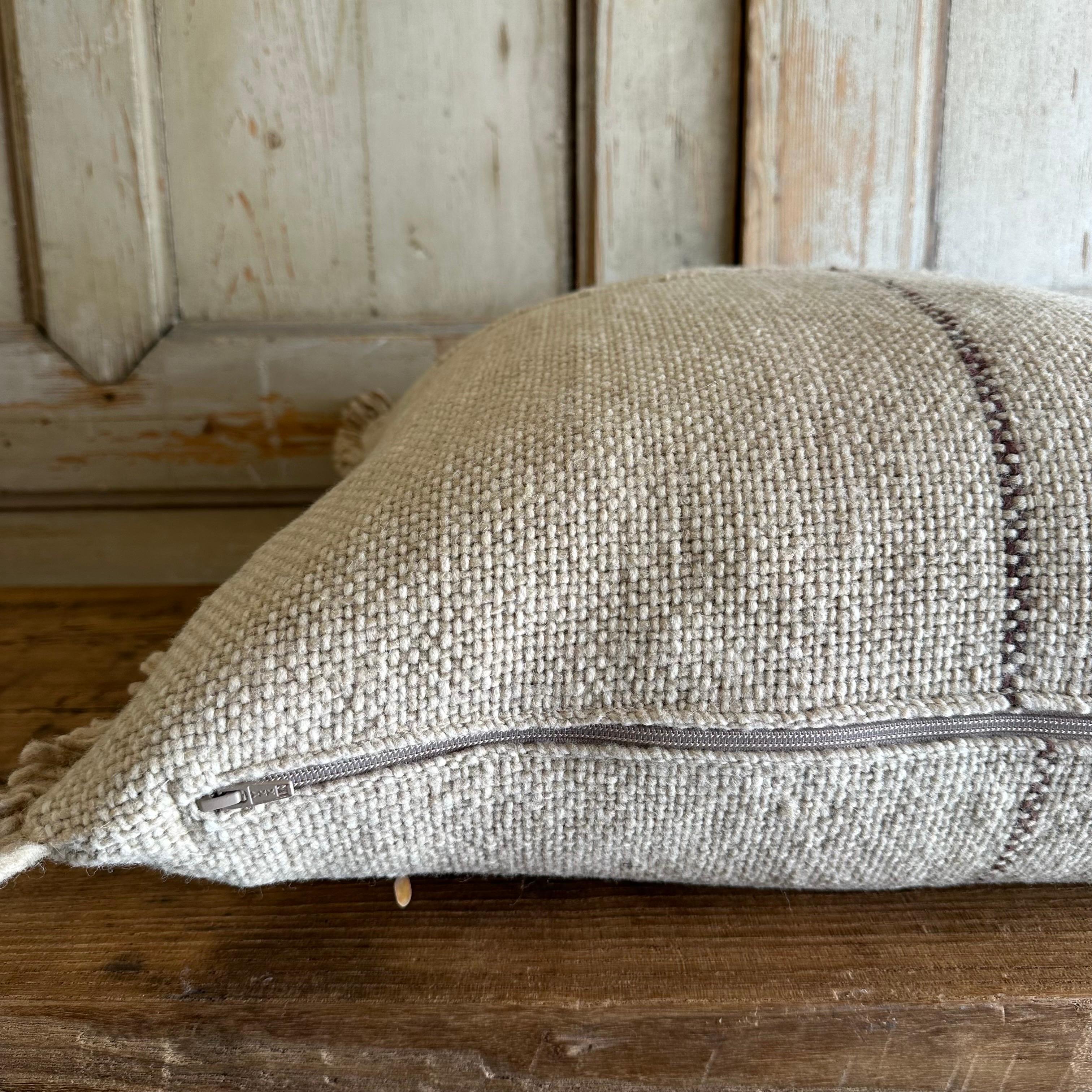 Wool Alpaca accent pillow from . A beautiful natural pillow with brown stripe and fringe. Large wood yarns woven to create a beautiful texture. Hidden zipper closure. Due to the unique yarns, the color varies which are normal and to be expected. If