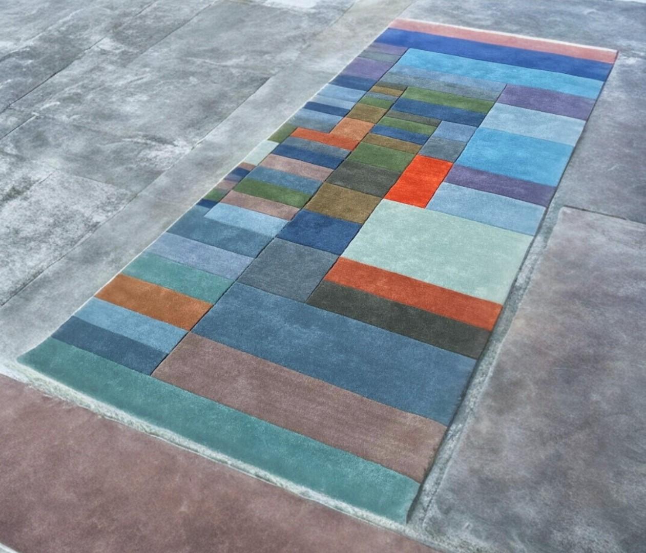 Custom hand knotted rug based on the painting “Fire in the Evening” by Paul Klee.

Size: 100 x 250 cm (3.3 x 8.2 ft). Further sizes, also bespoke, available.

Colors: 19 custom-dyed colors. Main colors of the rug are varied shades of blue, brown and