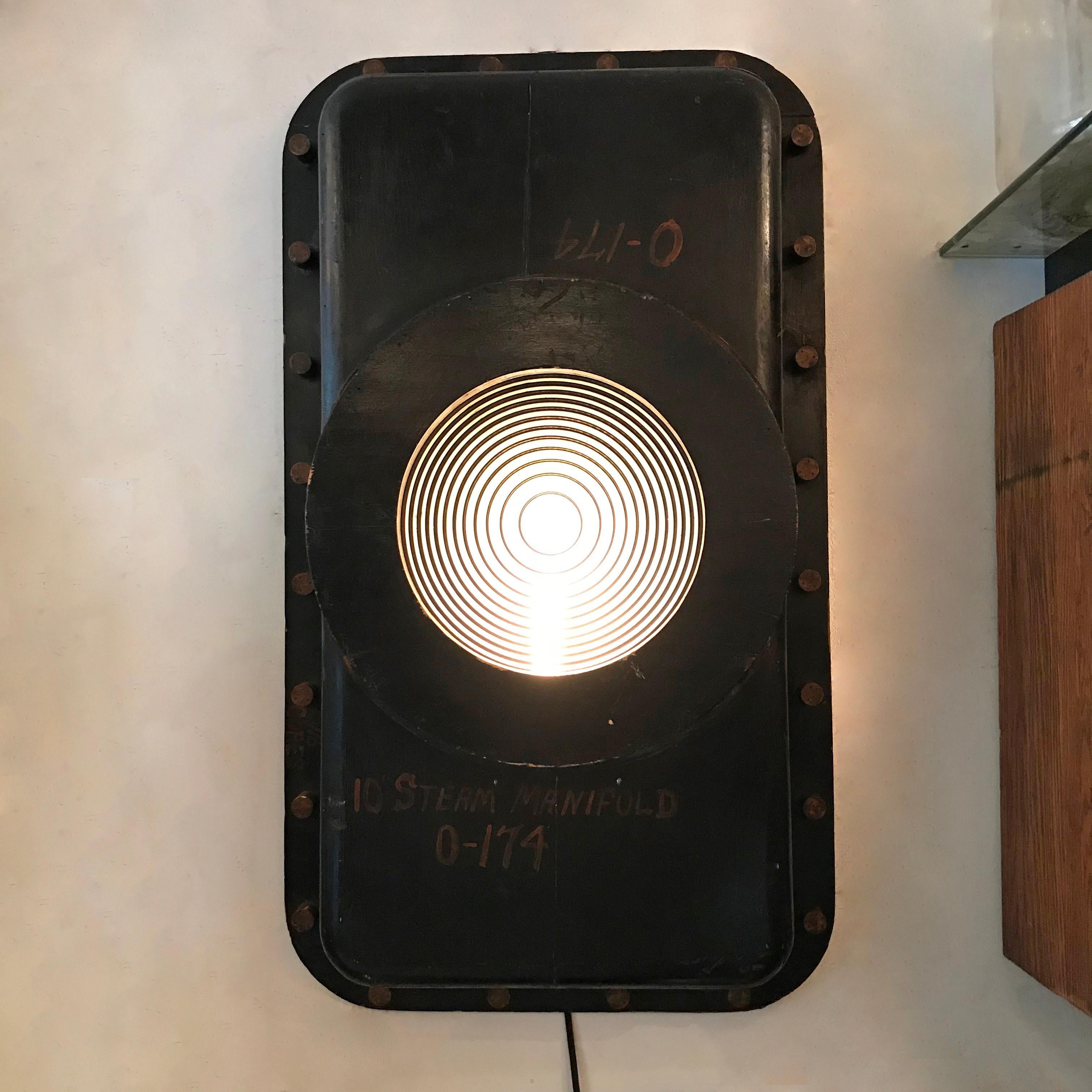 Large-scale, custom, industrial wall sconce light features a 1930s foundry pattern surround with Fresnel lens shade that is wired to accept up to a 150 watt bulb.