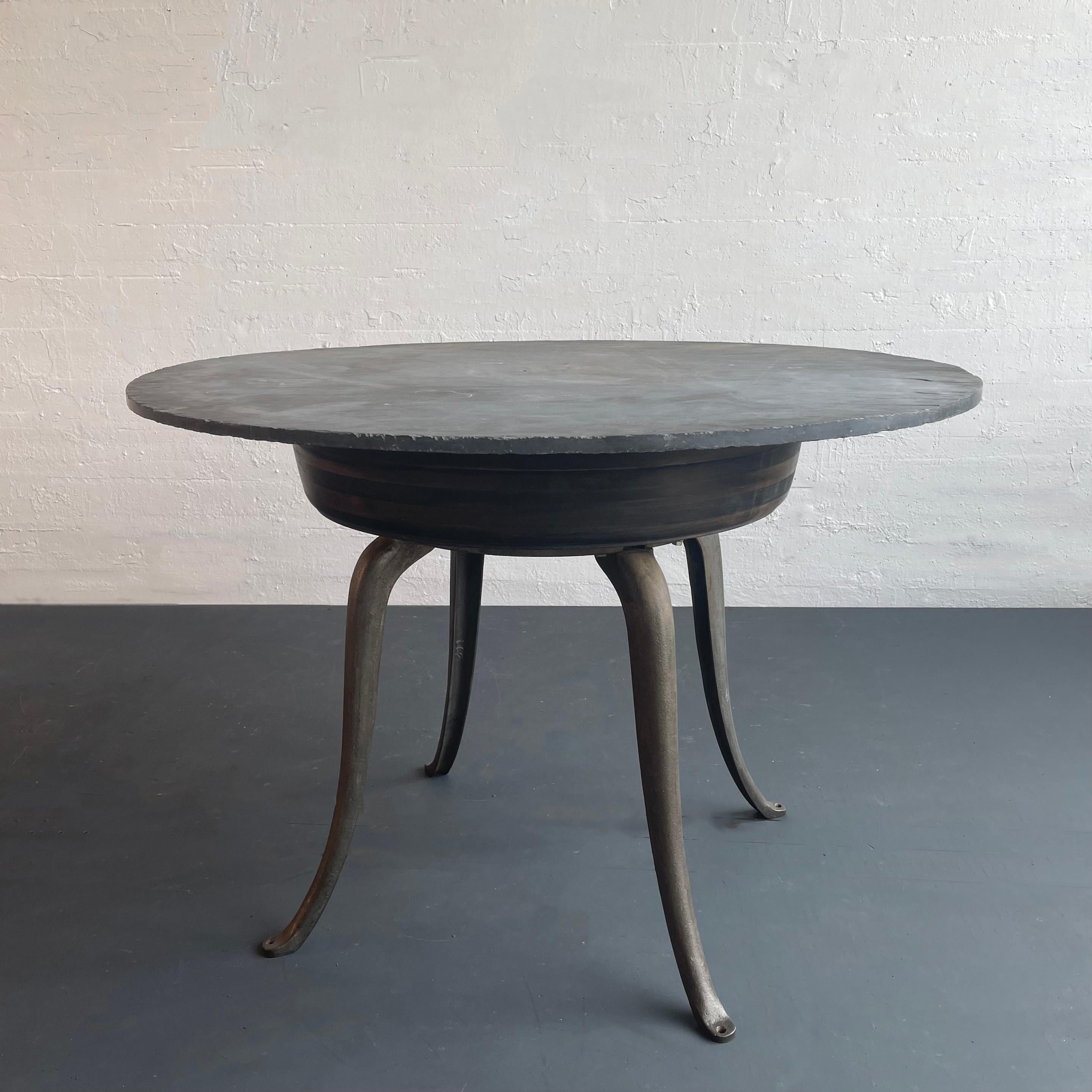 Il tavolo da pranzo industriale, centrale o alto, creato da cityFoundry a Brooklyn NY è caratterizzato da componenti unici dell'inizio del XX secolo. Il piano rotondo in ardesia grigia poggia su una fascia in acero ebanizzato sostenuta da eleganti