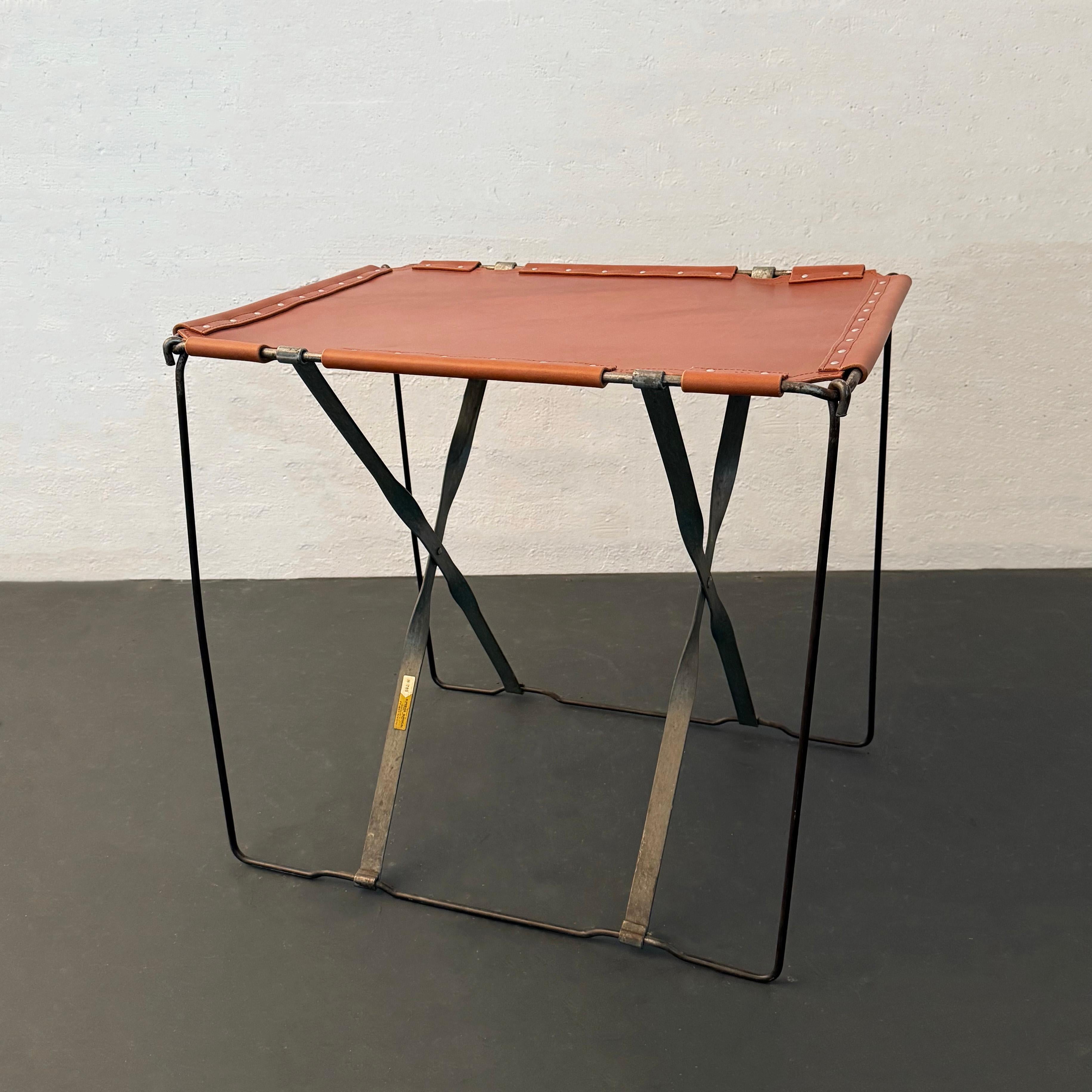 Cette belle table d'appoint industrielle sur mesure est composée d'un cadre de campagne en fil d'acier datant des années 1940 et d'un solide plateau en cuir. Le dessus est en cuir épais, coupé à la main et lugué, avec des coutures sellier cousues à
