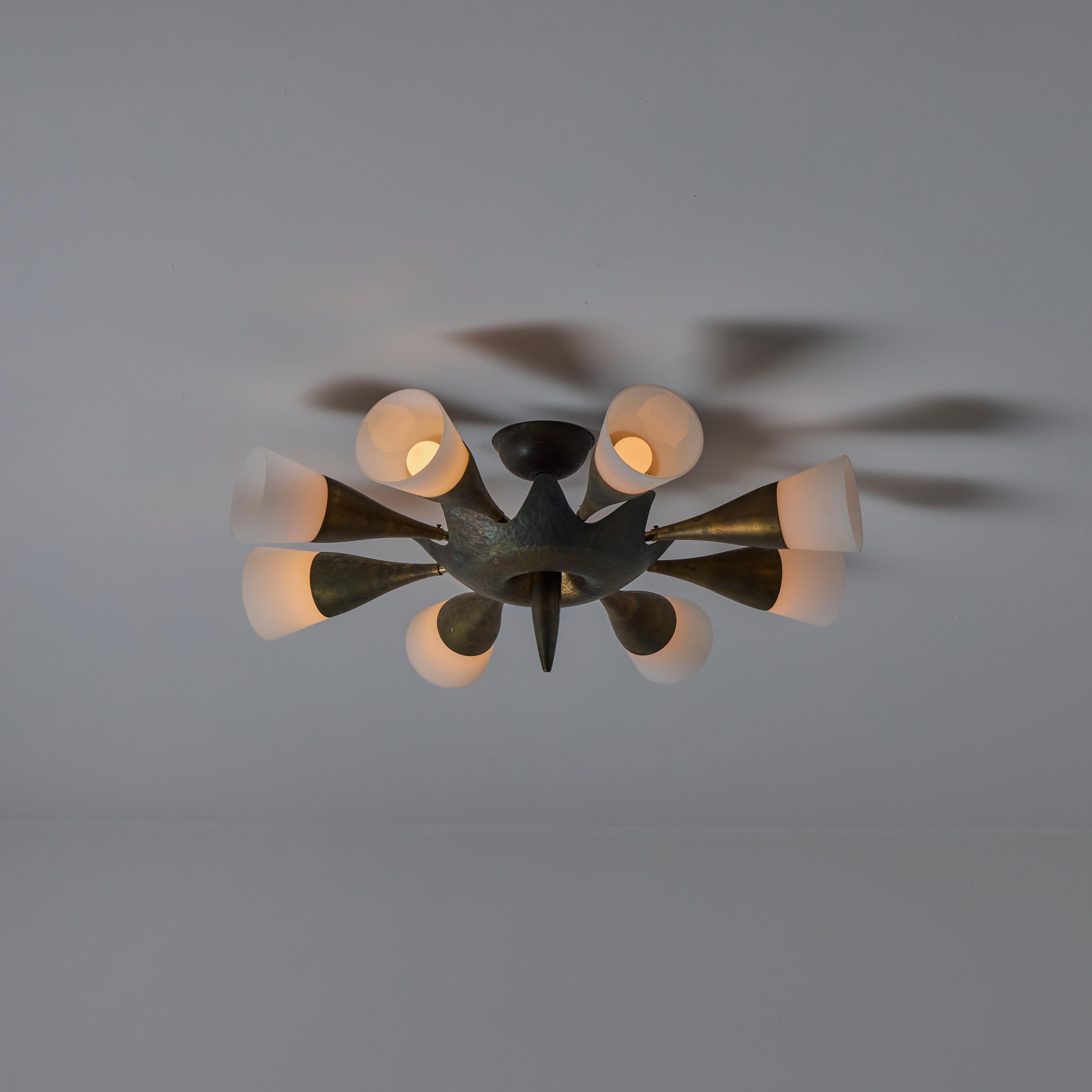 Custom Italian flush mount. Manufactured in Italy, circa the 1950s. Eight frosted glass flutes make up the circumference. Details of beautiful aged brass accents marry all around with a dramatic bottom center spike. Each flute holds a single e14