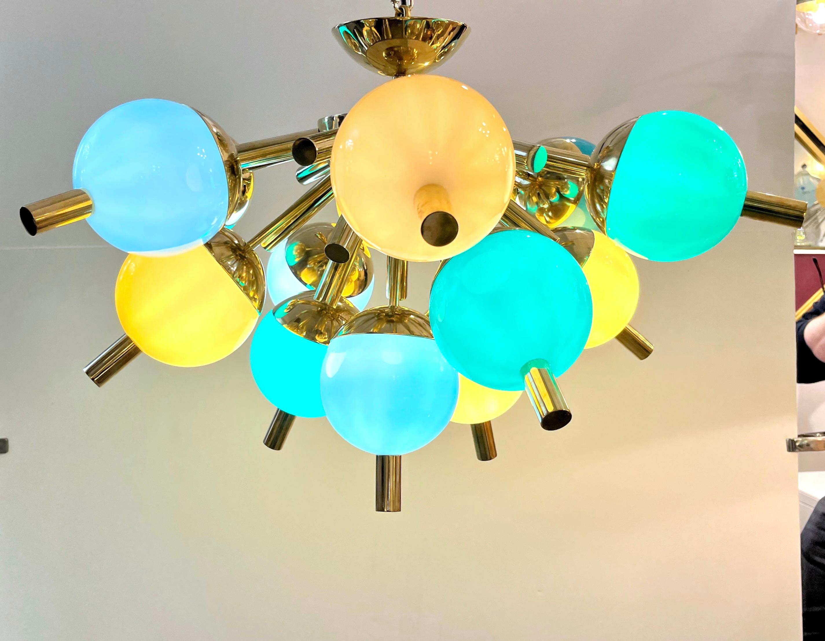 Who says that a small chandelier cannot be TOTAL FUN?! A bespoke contemporary thirteen-light Italian half sputnik fixture, with Mid-Century Modern design, entirely handmade in Italy, with a brass structure; gold brass rods are jutting out of a