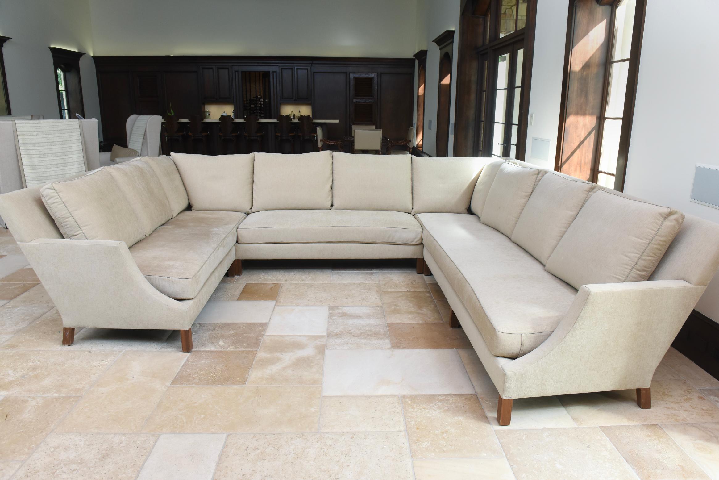This exquisite L-shaped sectional sofa by Holly Hunt, designed by John Hutton in 2011, showcases timeless elegance and masterful craftsmanship. Featuring a Left Arm Facing (LAF) design with a graceful tuxedo back, creating a striking and versatile
