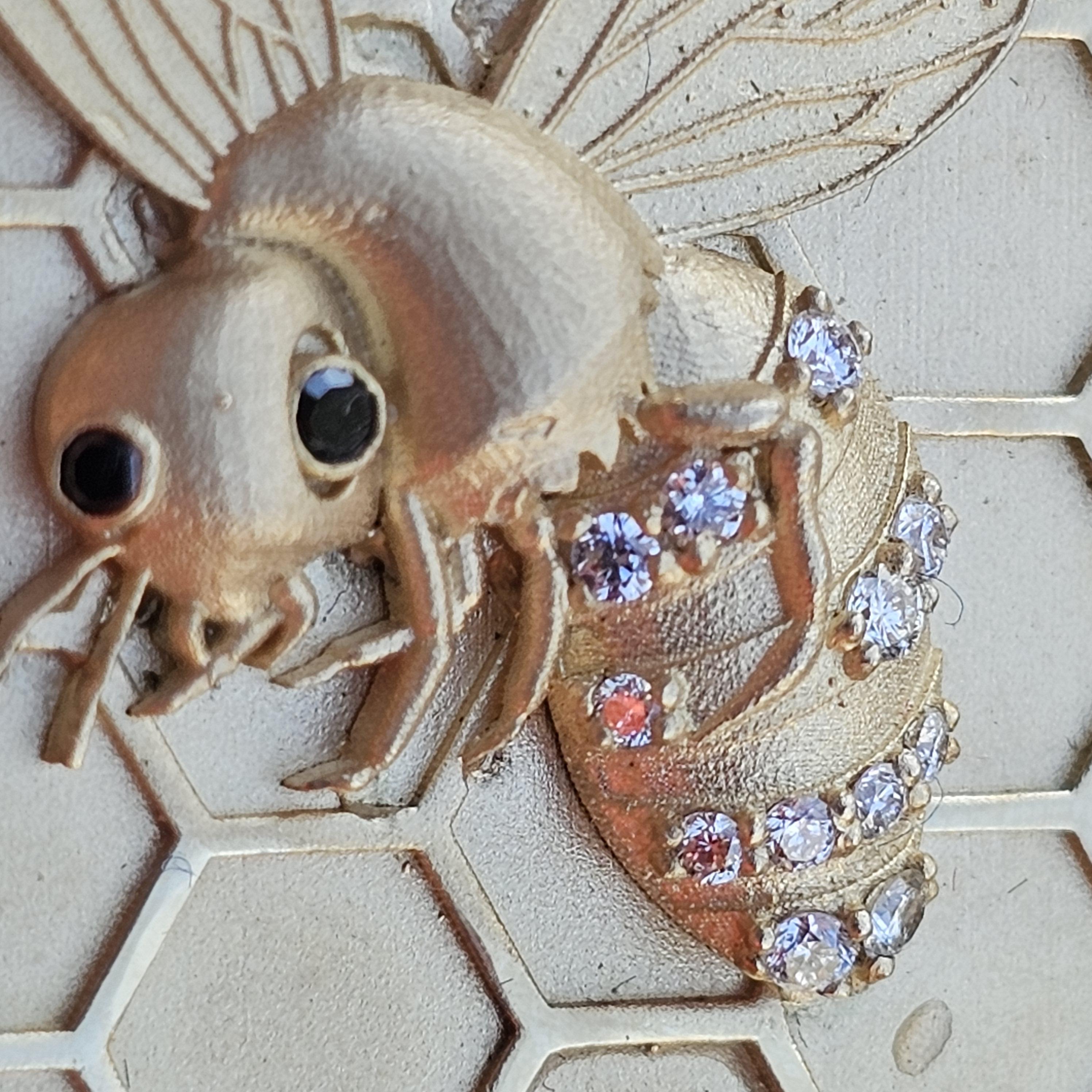 Ecco una collana con ciondolo unica e personalizzata con un motivo ape dettagliato su uno sfondo a nido d'ape. Realizzato in oro giallo massiccio 14k, questo pezzo è impreziosito da diamanti bianchi che accentuano il corpo dell'ape.  Gli occhi di