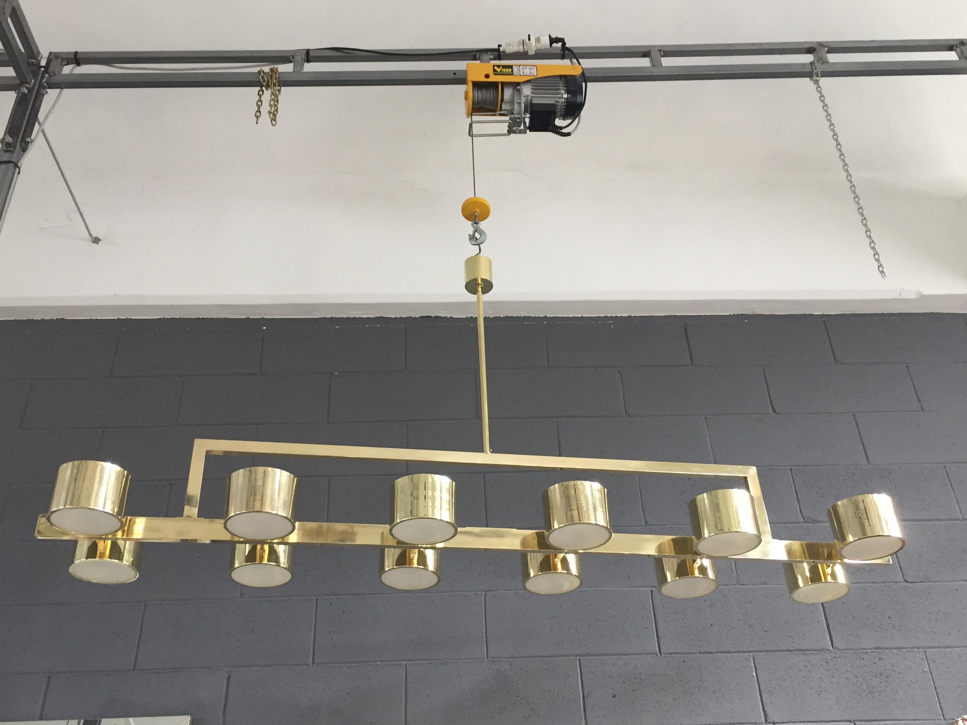Lustre rectangulaire en laiton avec 12 lumières cylindriques. Peut être réalisé dans d'autres métaux et d'autres tailles