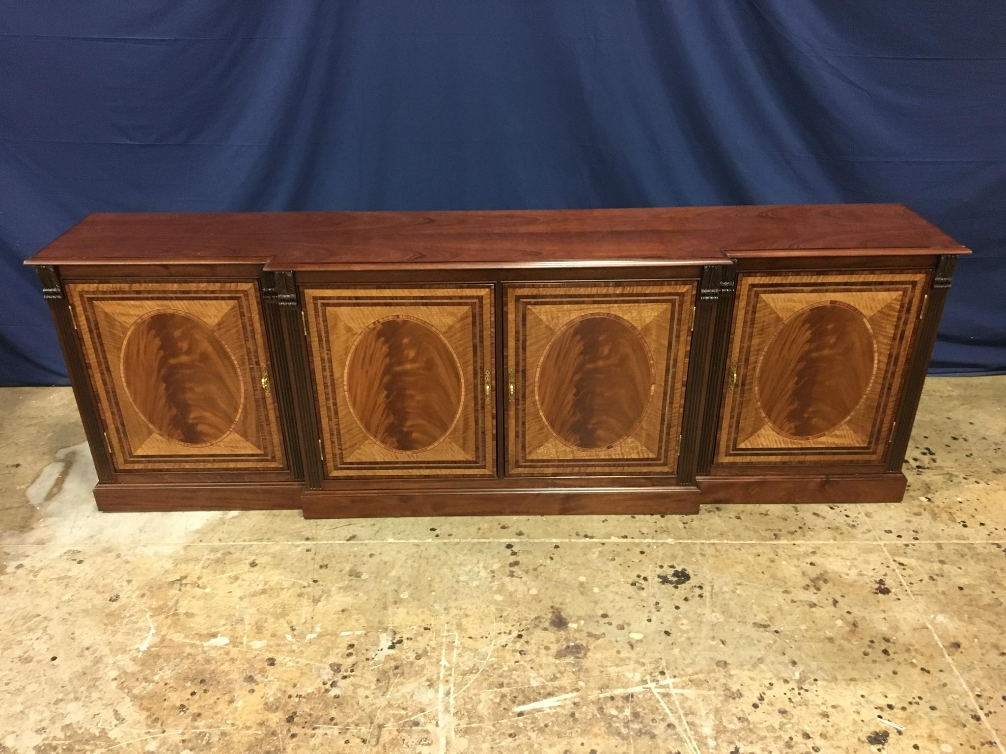 This is made-to-order traditional mahogany four door buffet or credenza made in the Leighton Hall shop. It features four doors with swirly crotch mahogany fields and satinwood and Santos rosewood borders. It has a cathedral mahogany top with a
