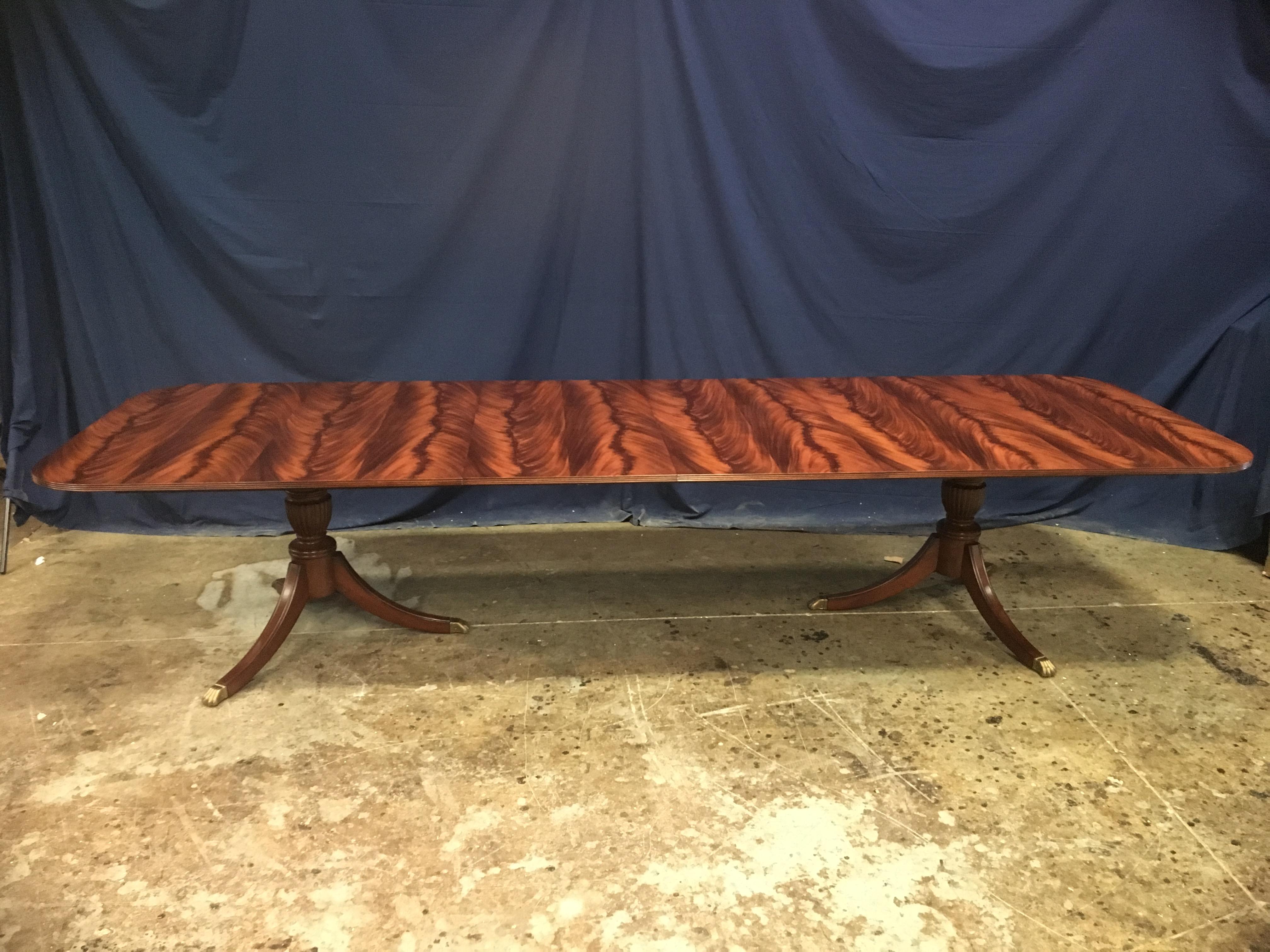 This is a made-to-order traditional mahogany dining table made in the Leighton Hall shop. It features a field of reverse slip-matched swirly crotch mahogany from West Africa. It has a hand rubbed and polished semi-gloss finish. The Sheraton-style
