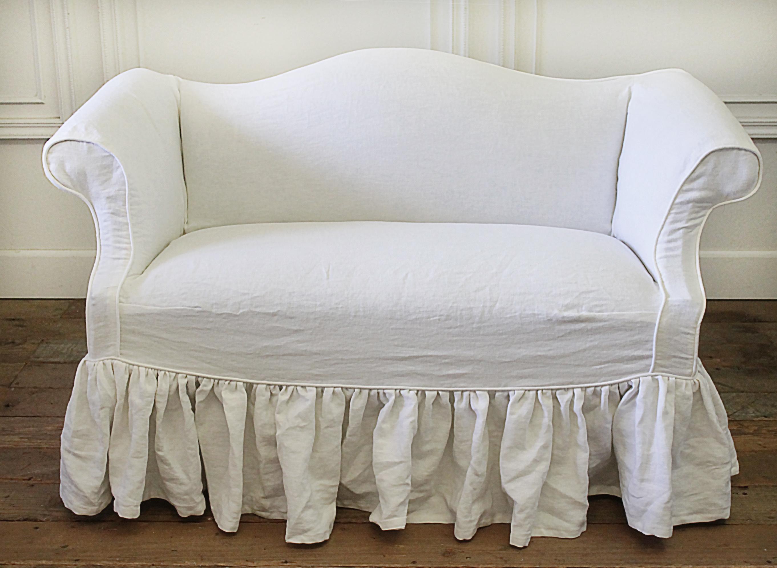 Custom linen slip covered vintage petite sofa in toile
Chippendale style petite bench or sofa, upholstery in a dark brown and natural toile.
We custom made a white Belgian linen slip cover with long ruffle drop. Our linen has been pre washed to