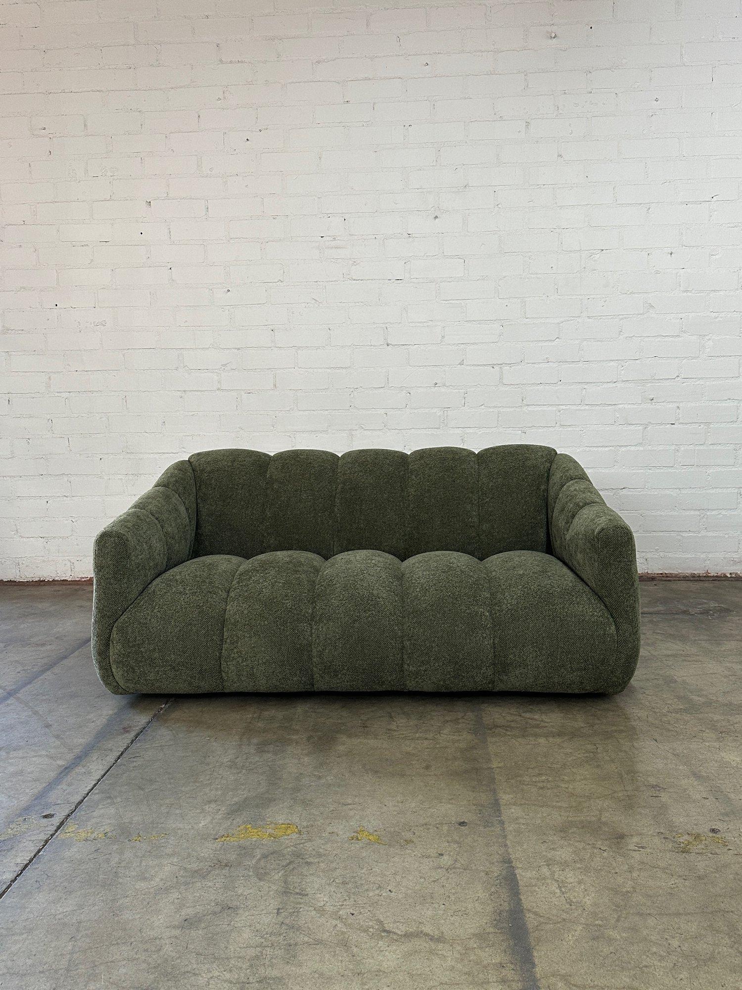 W61 D37 H26.5 AH23 SW50 SD23 SH13

Handcrafted loveseat version of our channel sofa made from scratch in house. Loveseat features  hand tied springs, feather and foam for great comfort. Item has a green nubby boucle and sits on low profile